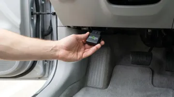 Azuga OBD-II tracker plugged into vehicle diagnostic port for installation