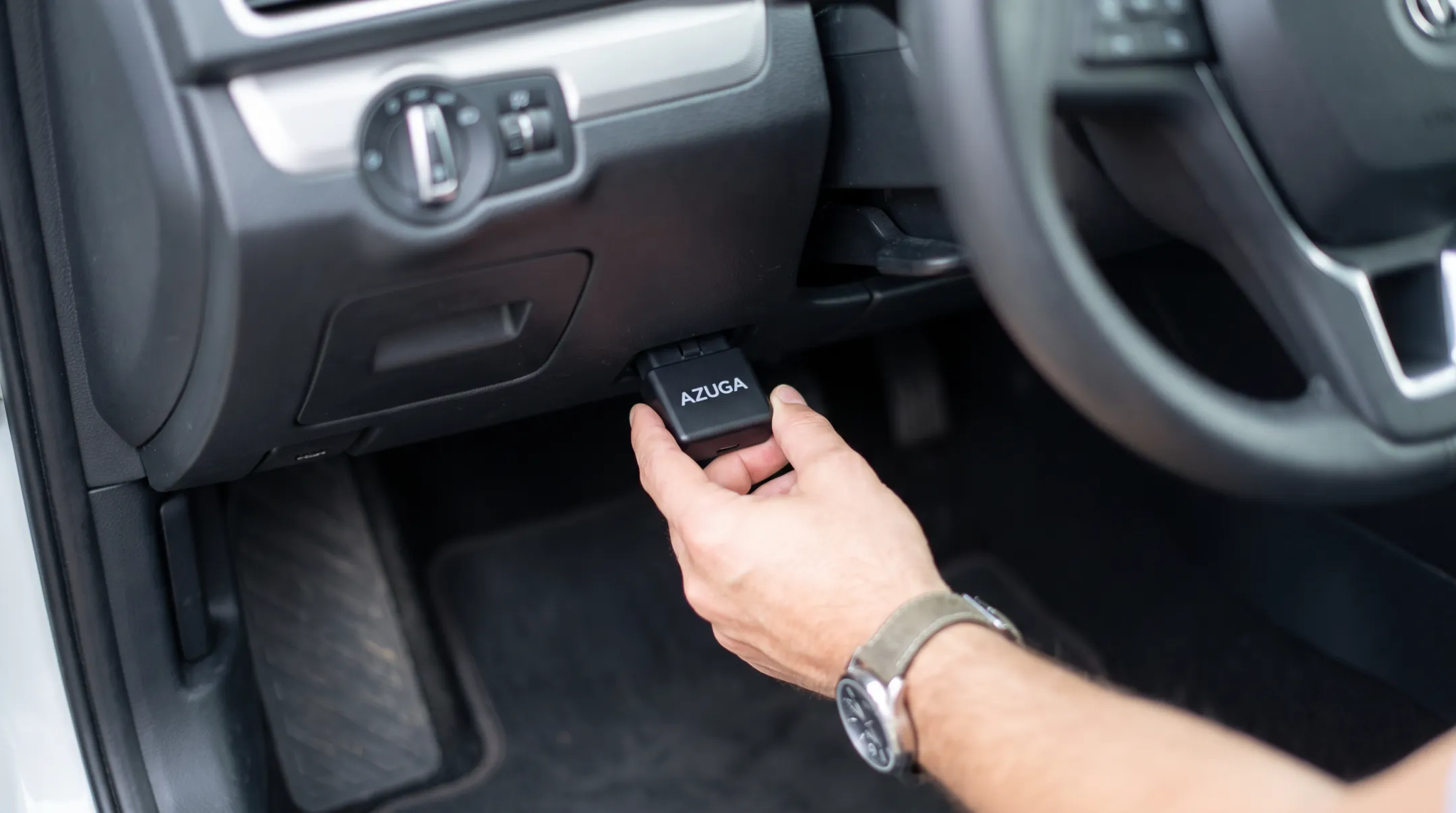 Plug-and-play OBD-II fleet tracker installing into vehicle diagnostic port