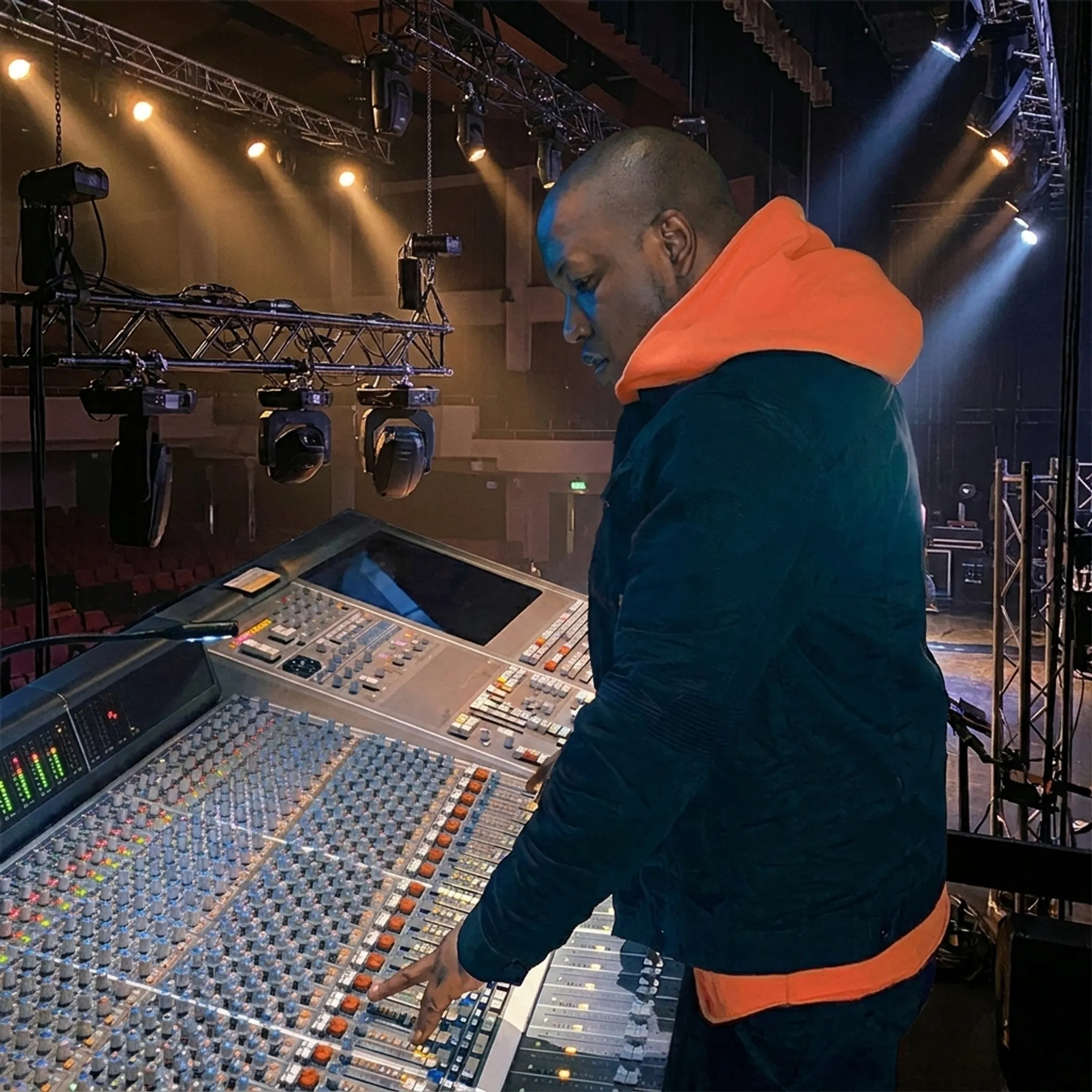 Live sound and lighting technician managing stage audio during an event