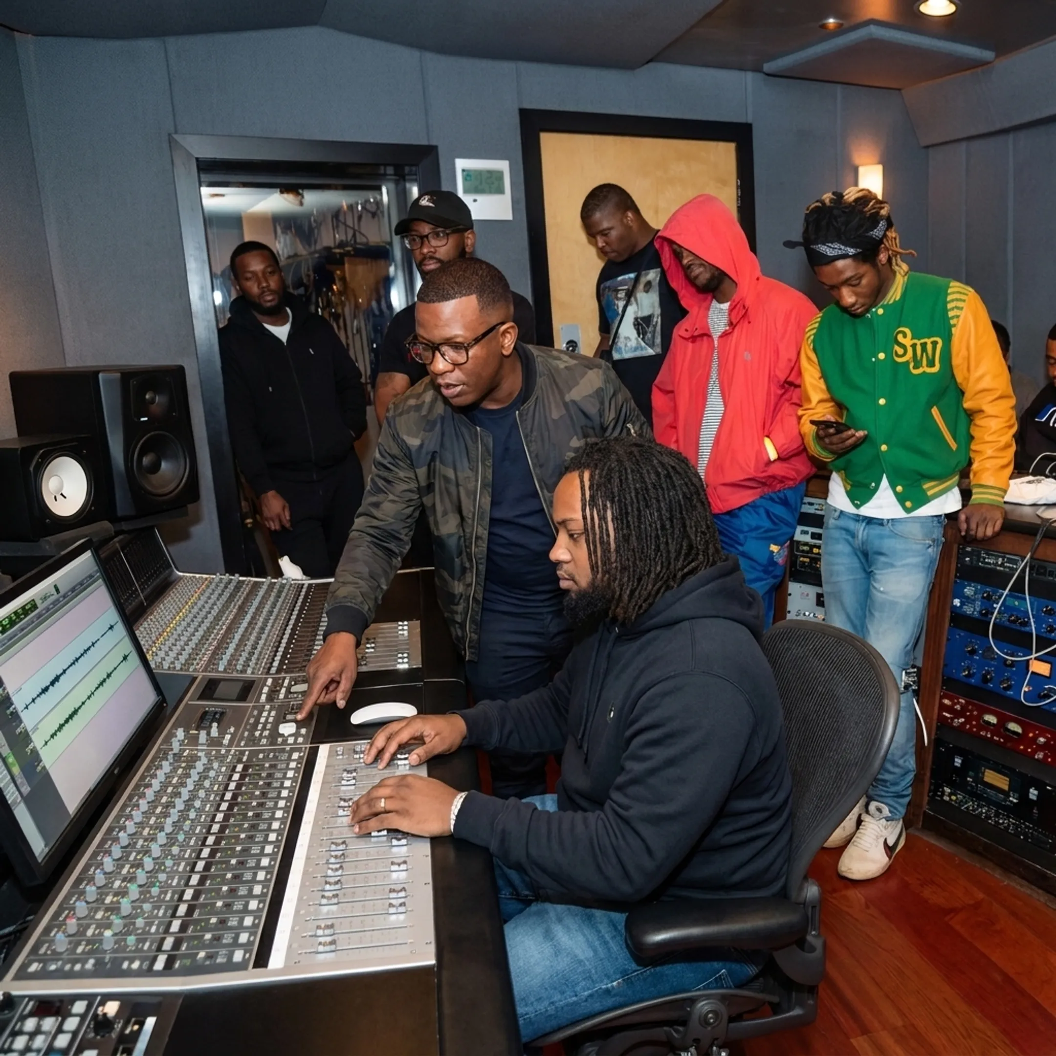 Music manager and artist discussing project rollout strategies inside a modern recording studio