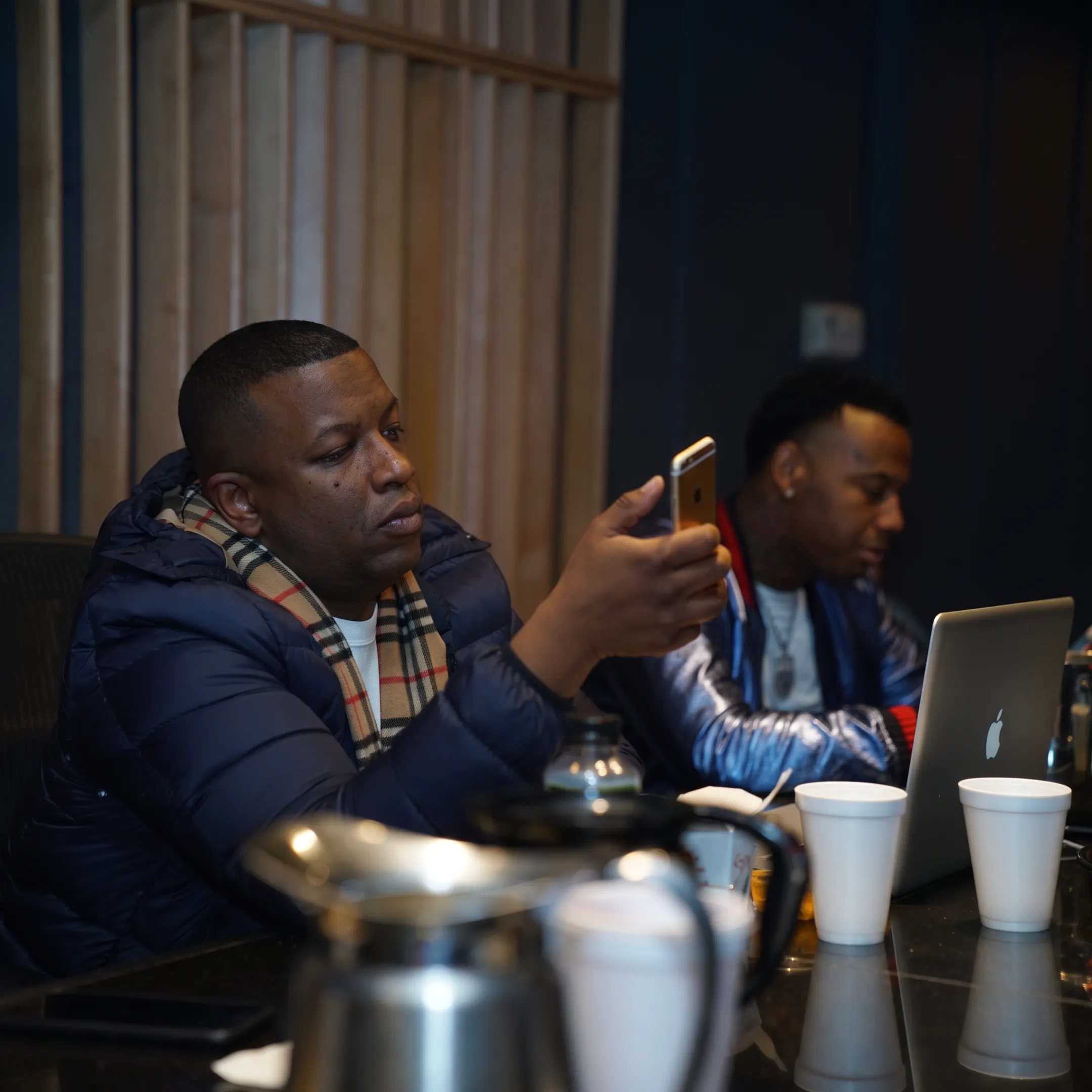 Music promotion manager discussing artist strategy in a recording studio