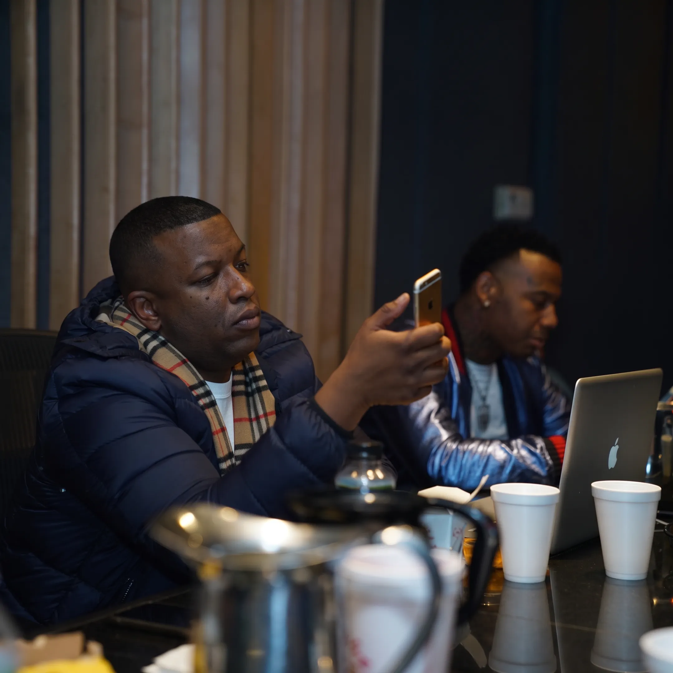 Artist manager and musician planning a UK release campaign around a studio table