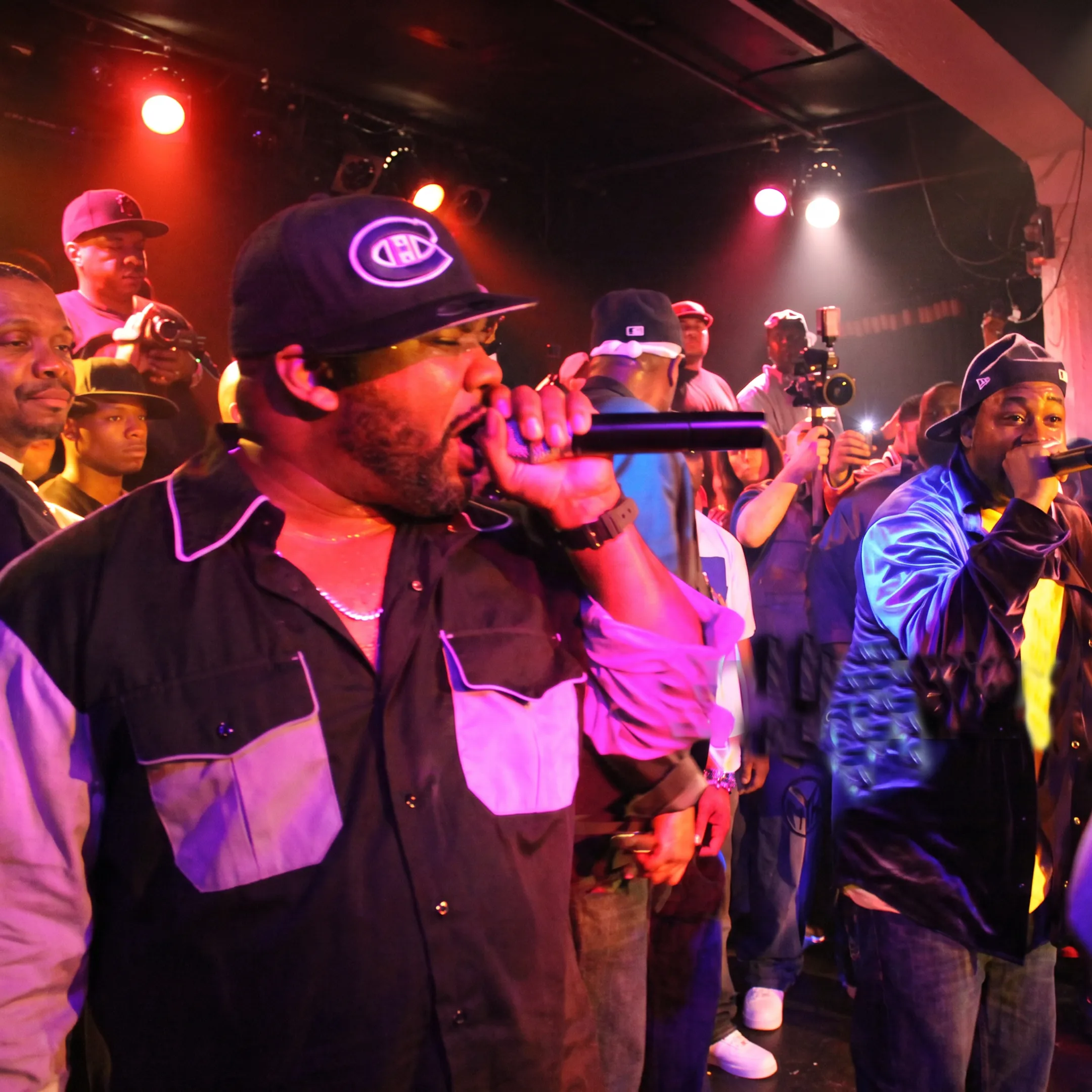 Artist performing onstage at a live concert while entertainment professionals coordinate the event