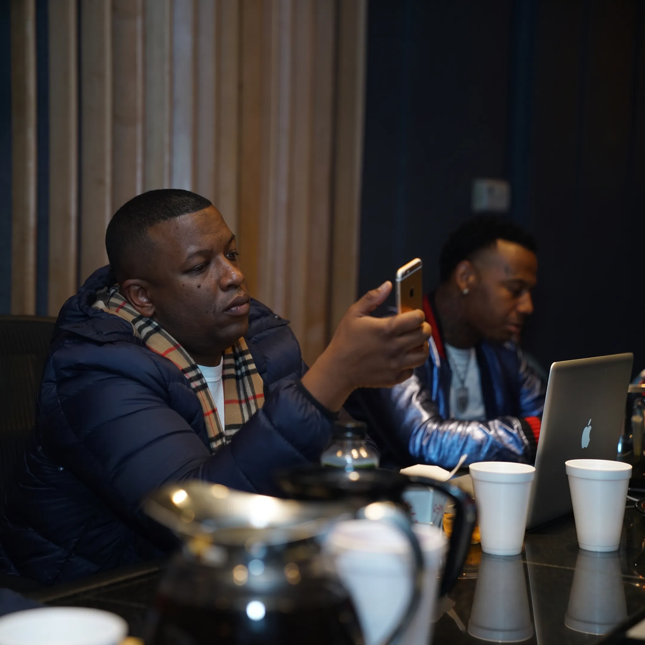 Entertainment manager reviewing artist strategy with musicians in a professional studio