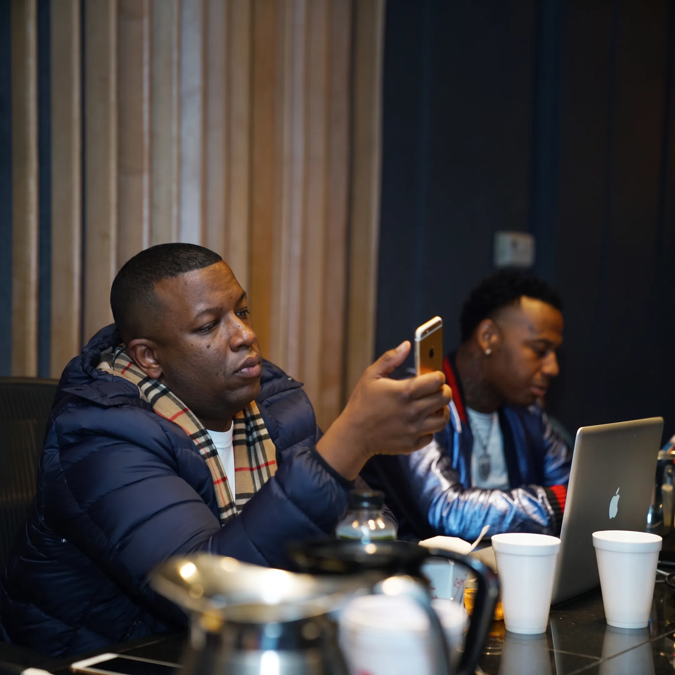 Artist and consultant discussing a release strategy beside studio equipment