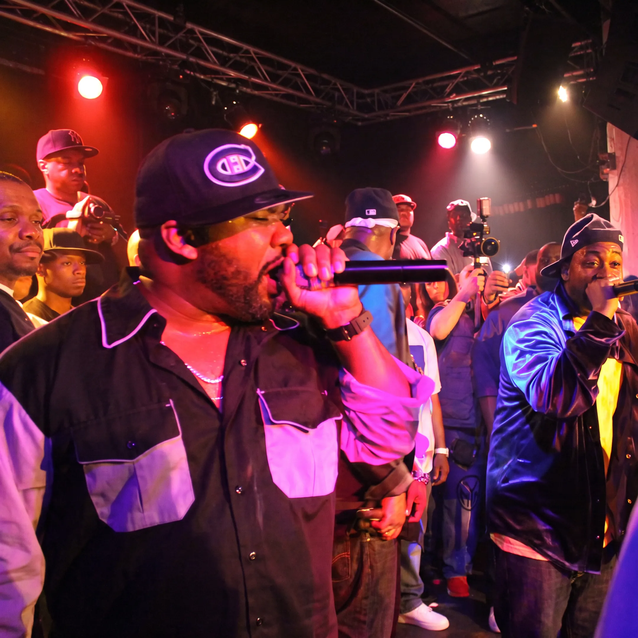 Hip-hop artist performing onstage while a promotion team works behind the scenes