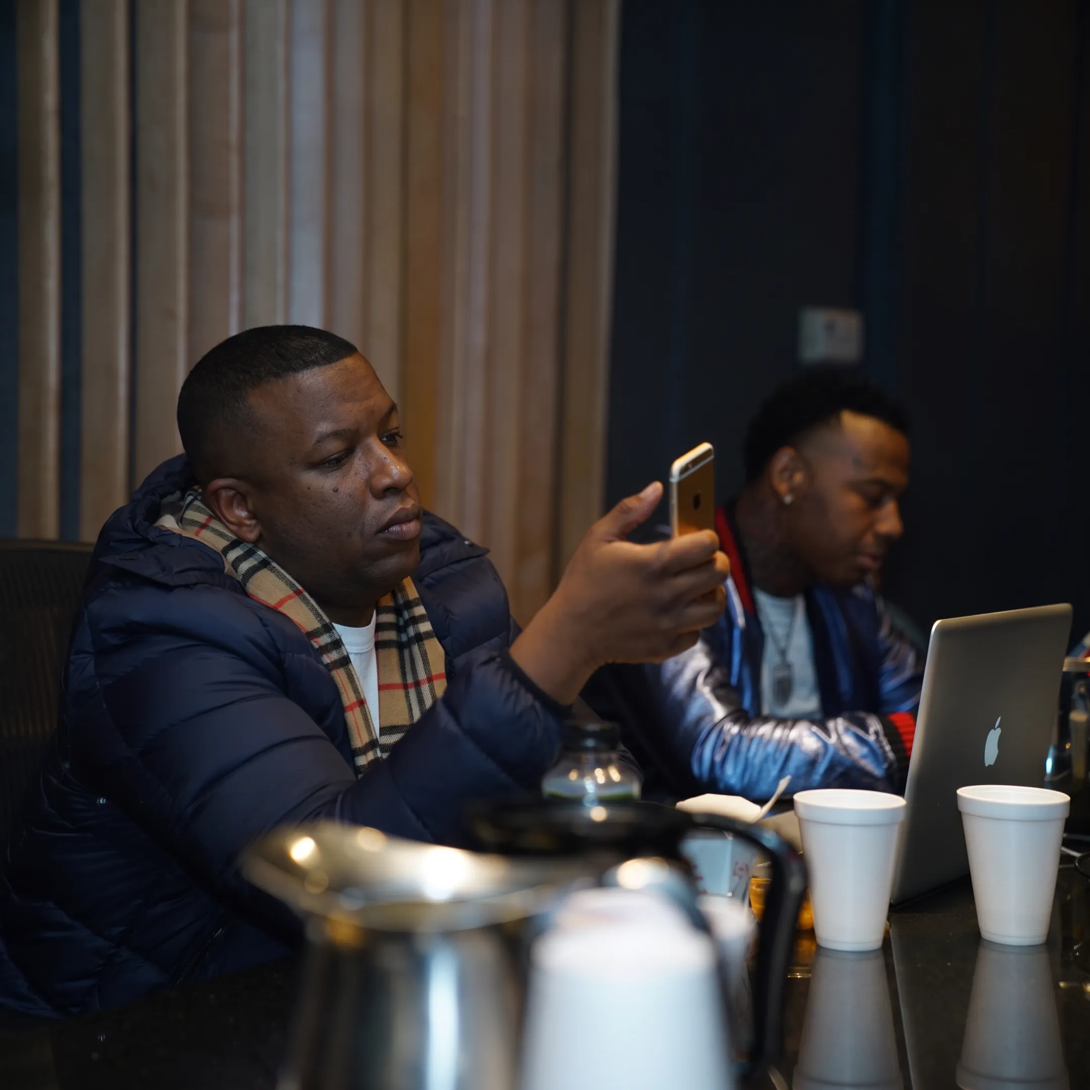 Artist and manager discussing release plans beside studio equipment