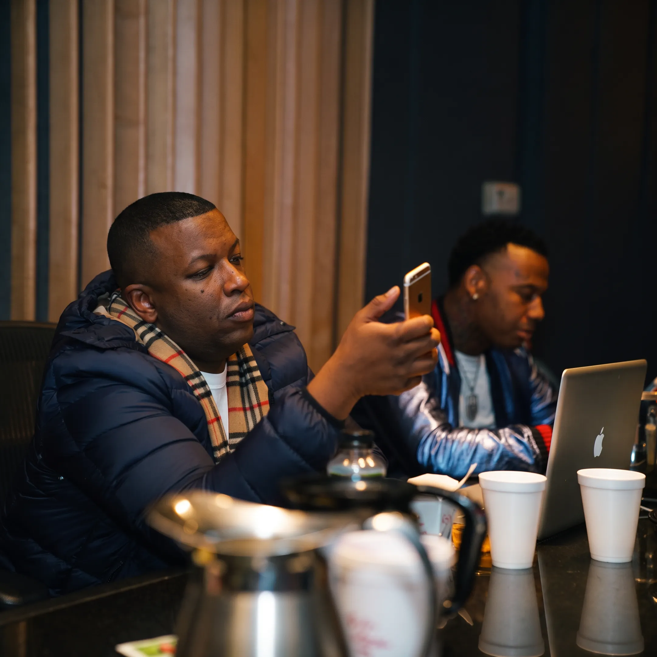 Music manager reviewing an artist strategy with performers in a professional studio
