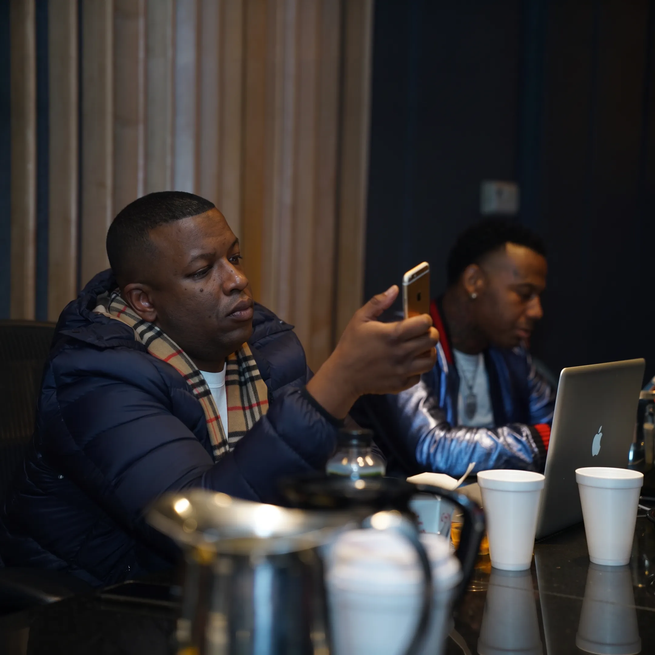 Independent hip-hop artist reviewing a promotional campaign with a music industry strategist