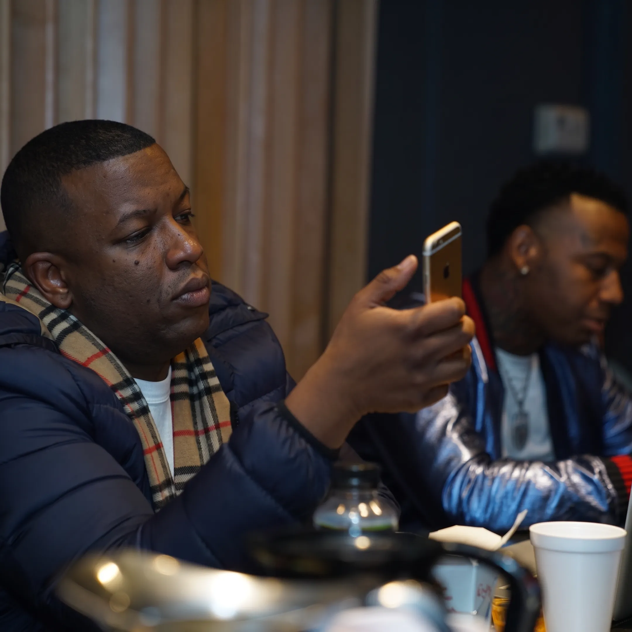 Hip-hop artist reviewing a release campaign with a marketing consultant