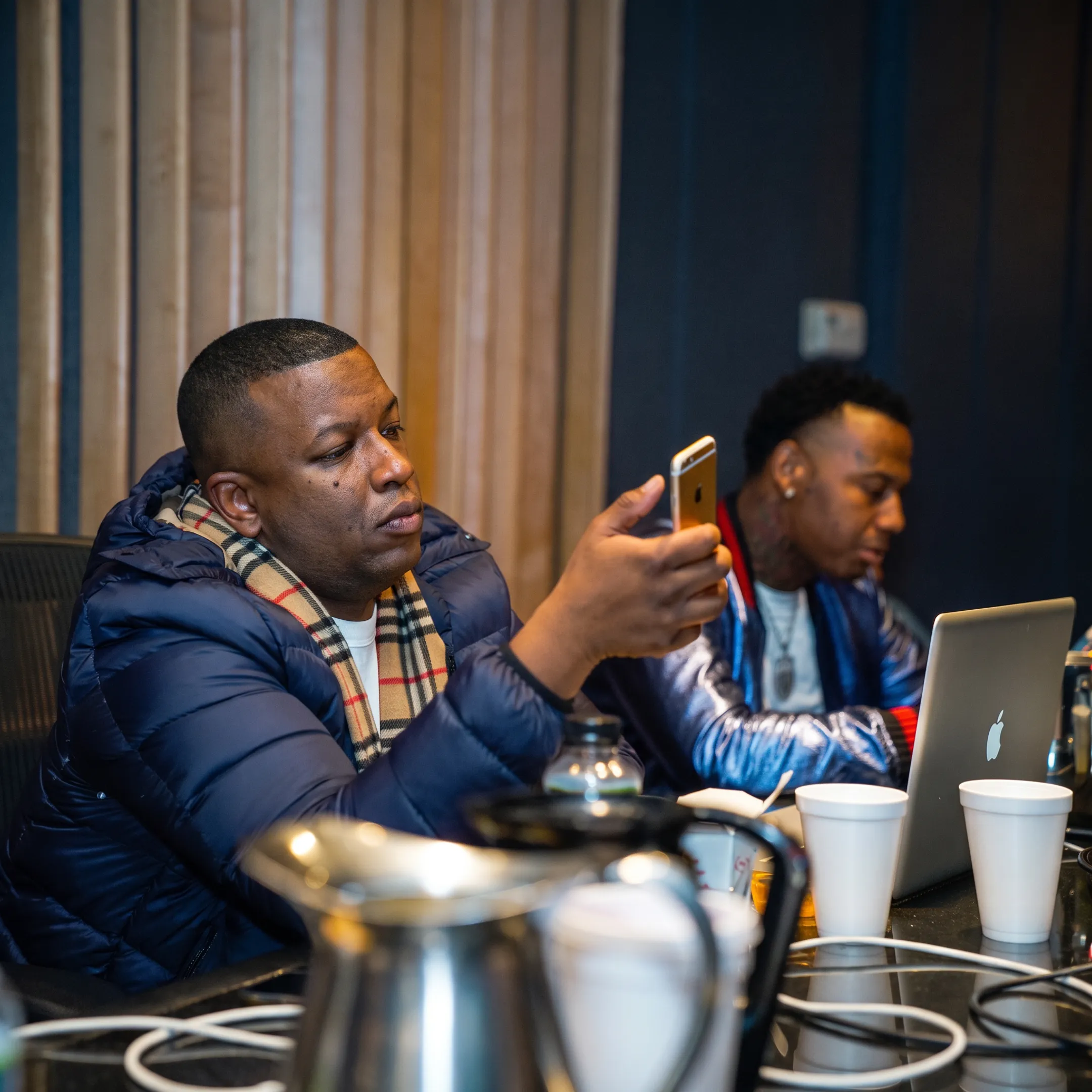 Artist and manager discussing release strategy beside studio equipment