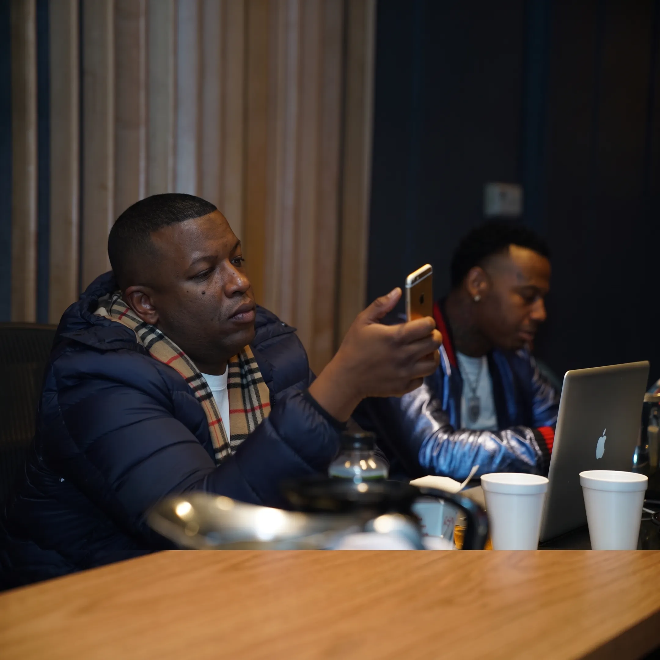 Music manager discussing booking opportunities with an artist in a recording studio