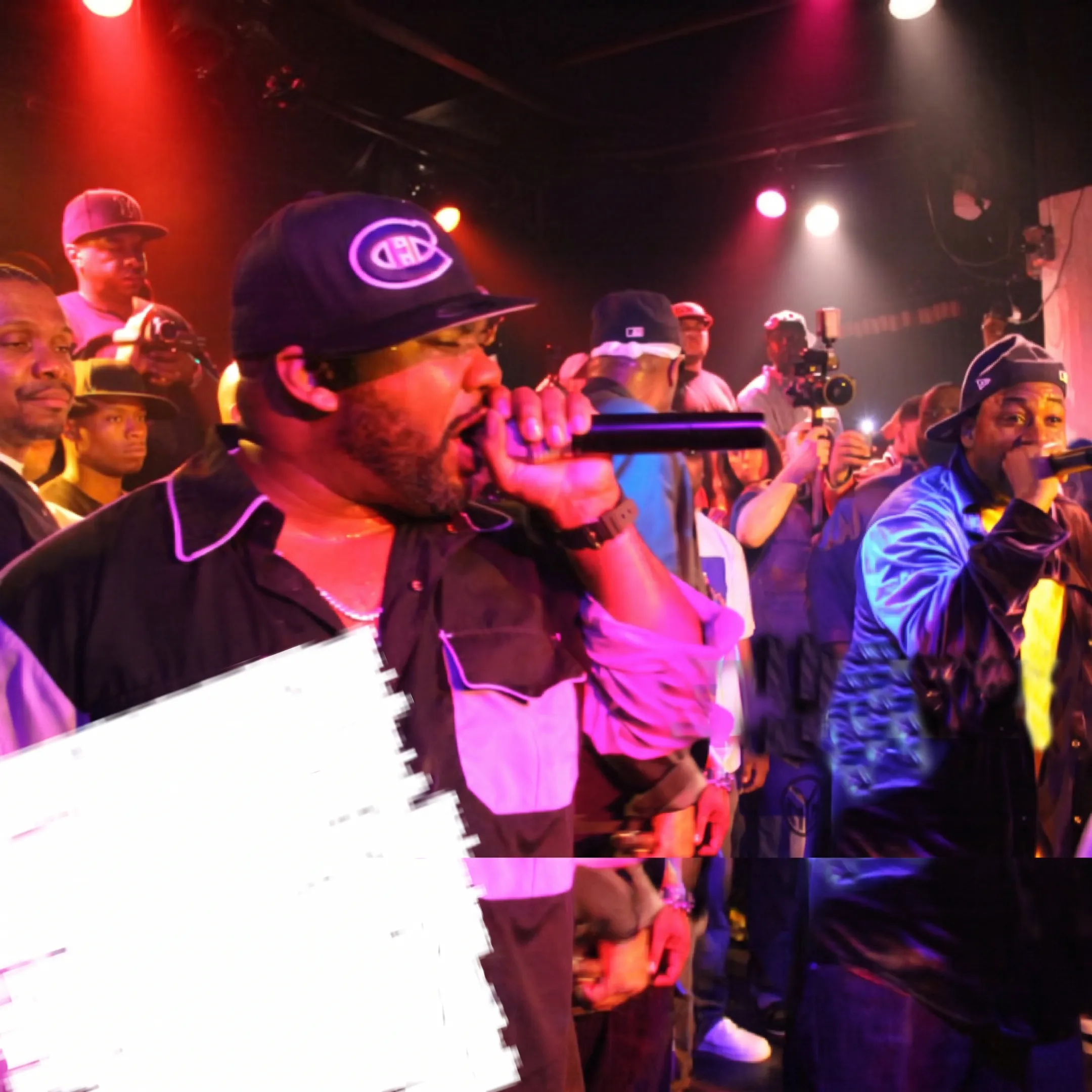 Independent artist performing onstage at a Houston music venue with agency professionals coordinating backstage