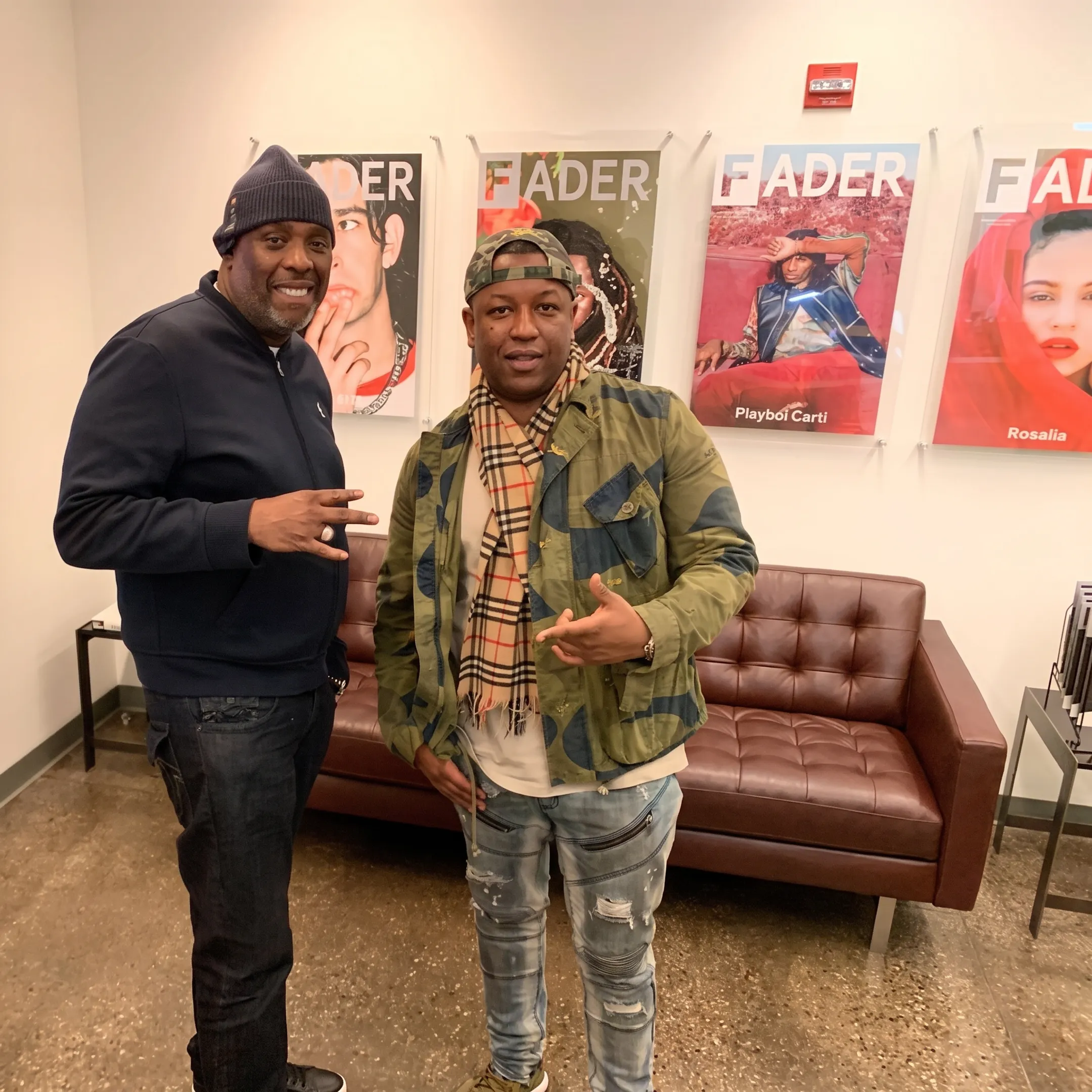 Hip hop artist reviewing digital marketing campaign visuals with an entertainment strategist