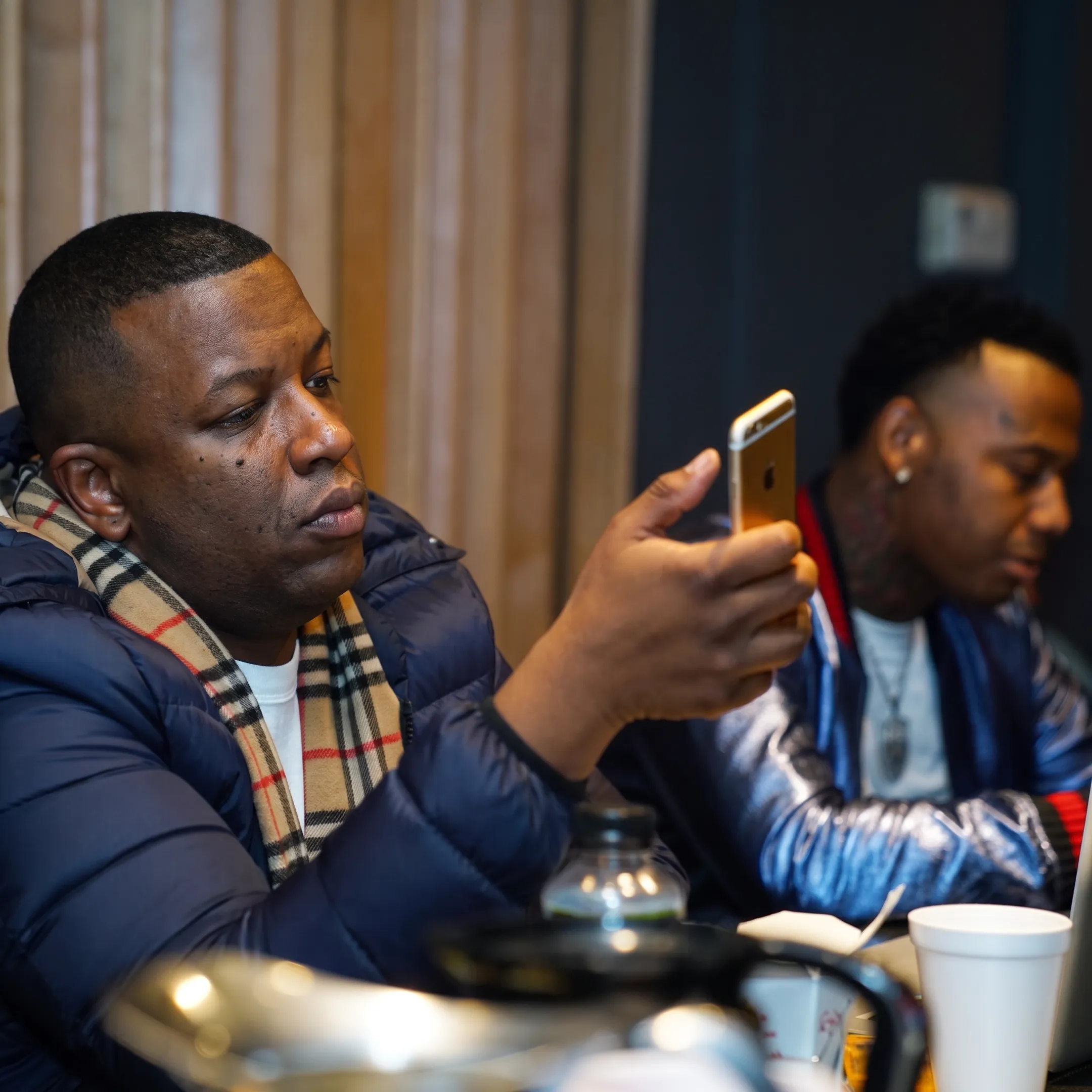 Rap artist and entertainment manager reviewing music, branding, and career strategy in a creative studio