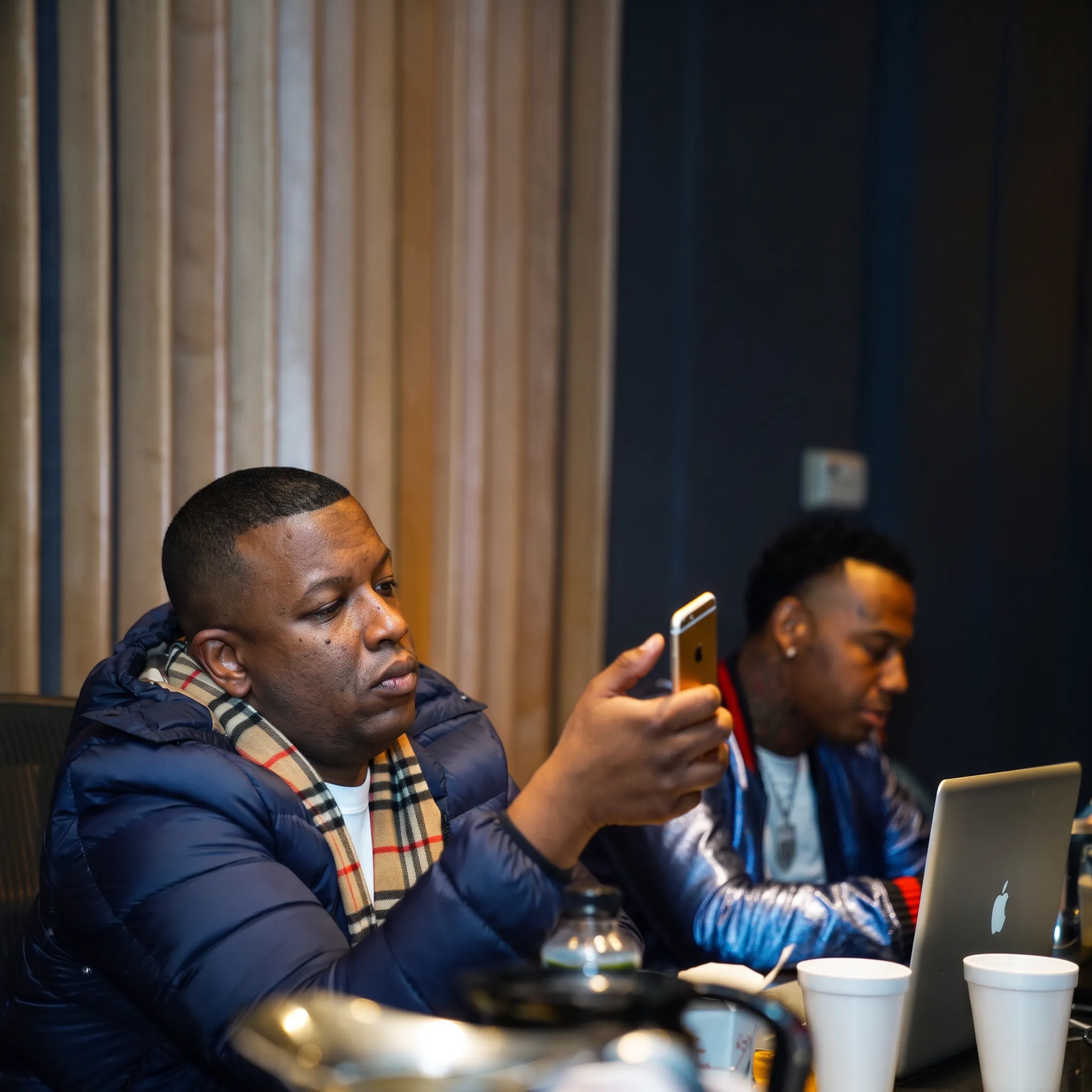 Music manager reviewing an independent artist’s release strategy with promotional materials in a creative studio