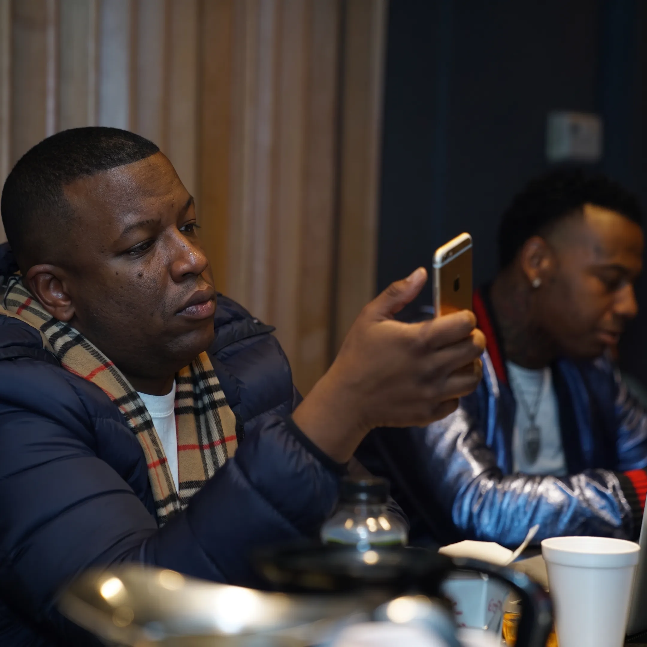Artist manager and musician discussing career plans beside studio equipment