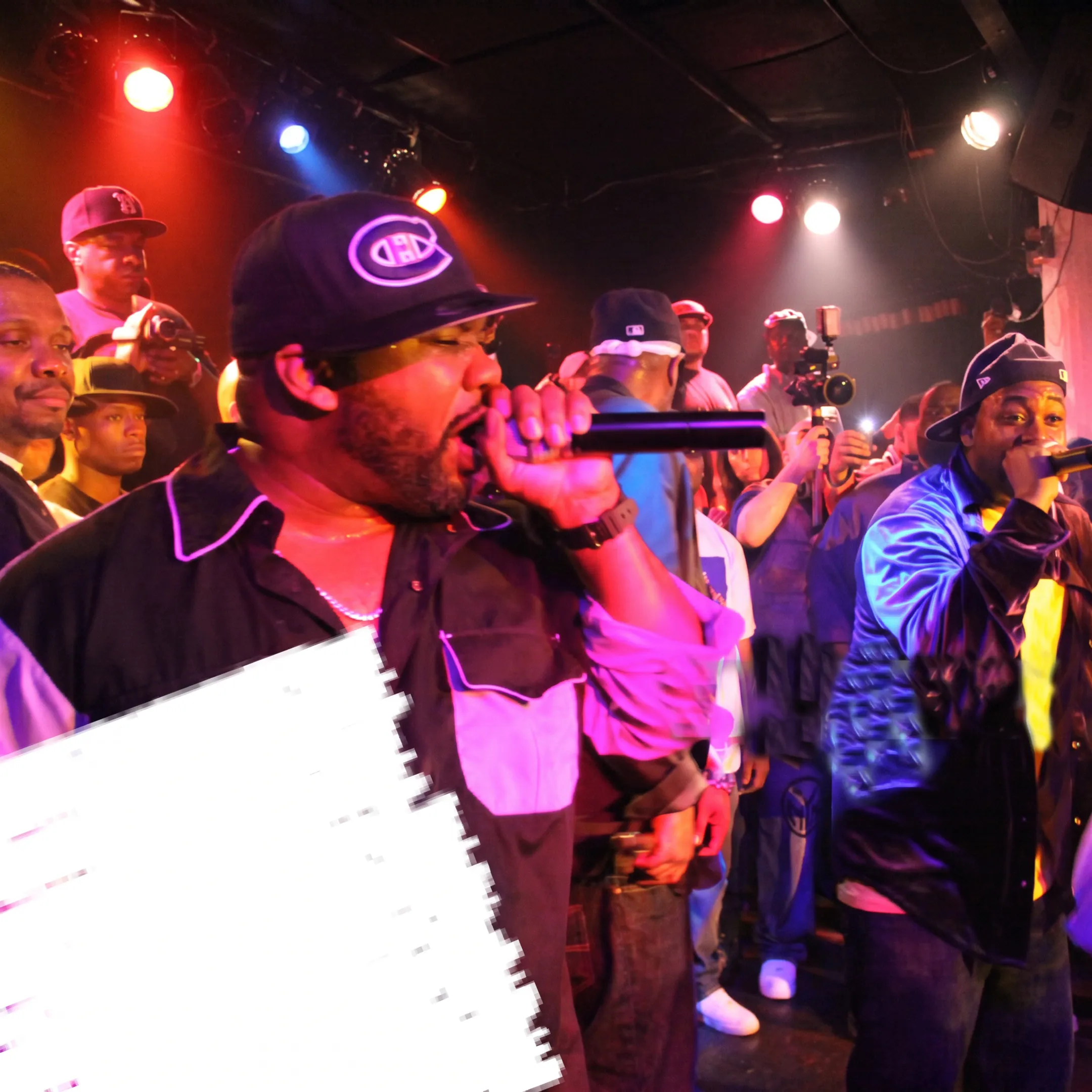 Rapper performing onstage at a crowded music event with professional lighting