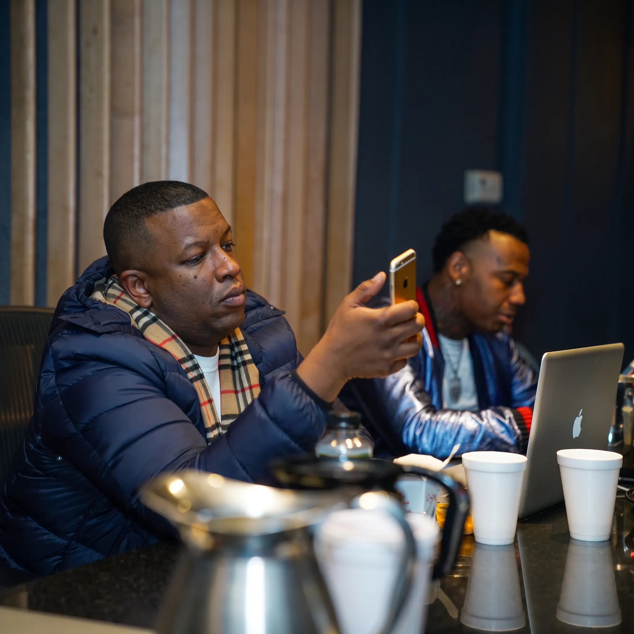 Music manager reviewing a rap artist’s promotional plan in a creative studio