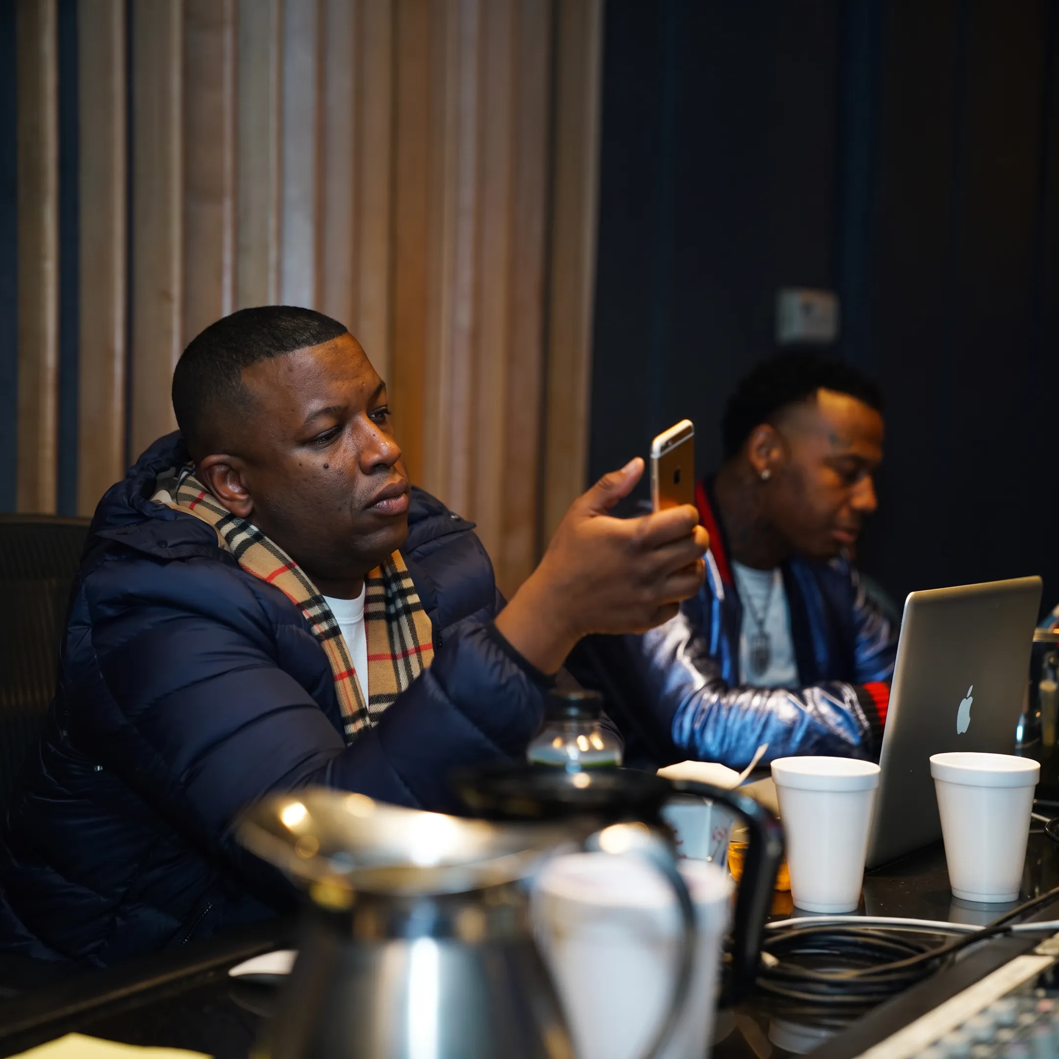 Music manager reviewing a rap artist’s promotional plan in a studio setting
