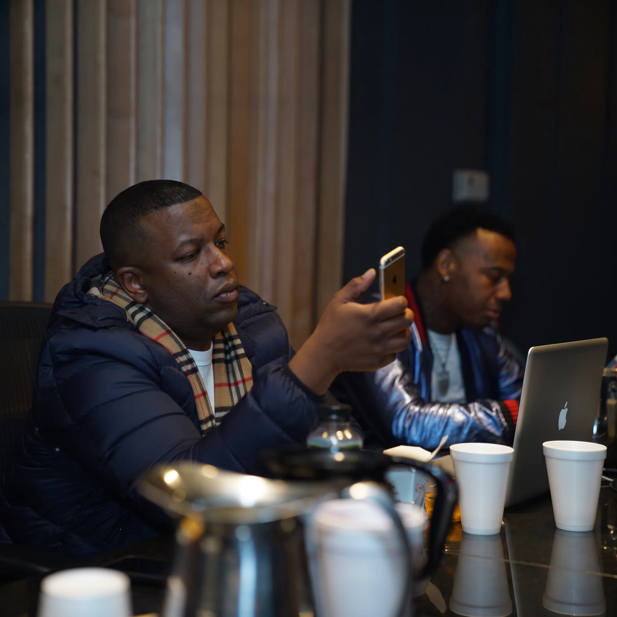 Music promotion team reviewing an artist release campaign with branding, media, and social content on screens