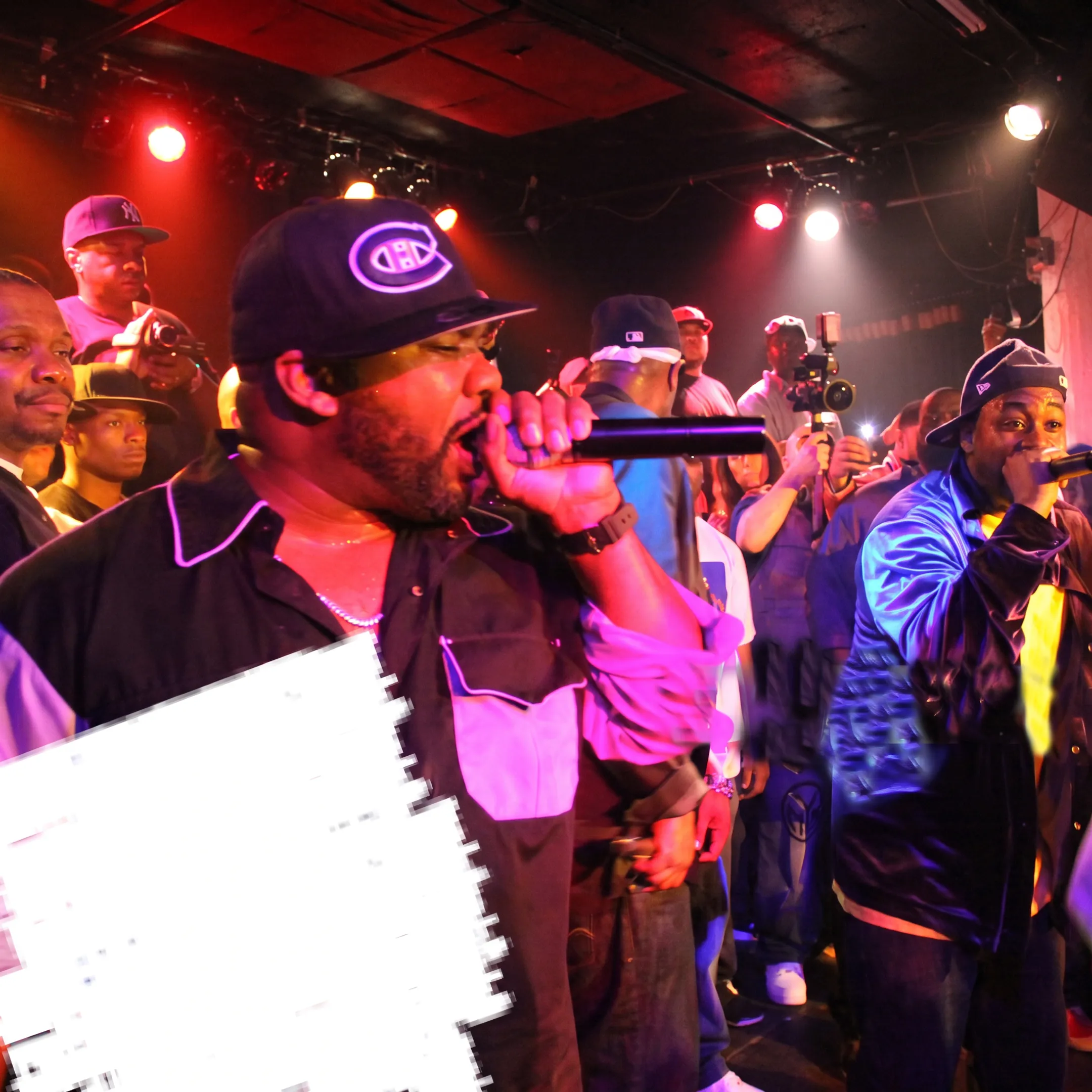 Rap artist performing onstage while a marketing team captures promotional content