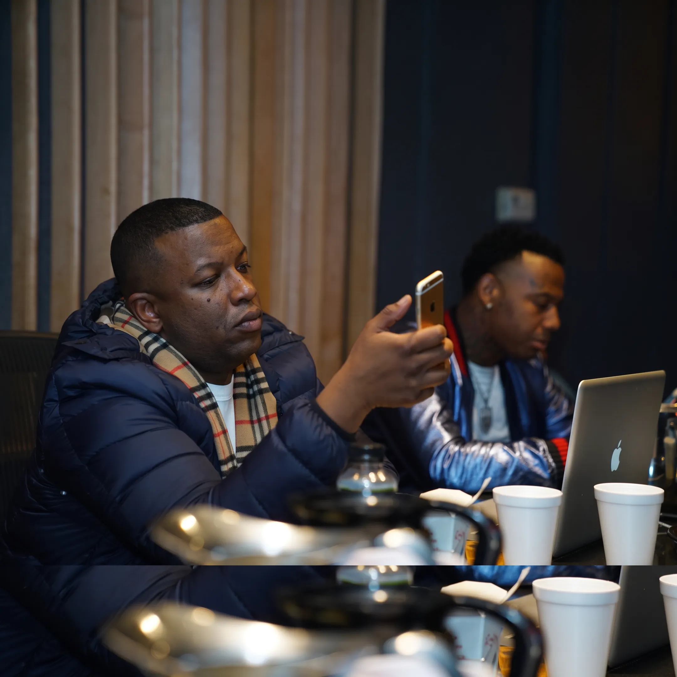 Hip-hop artist reviewing a publicity campaign with a music PR strategist