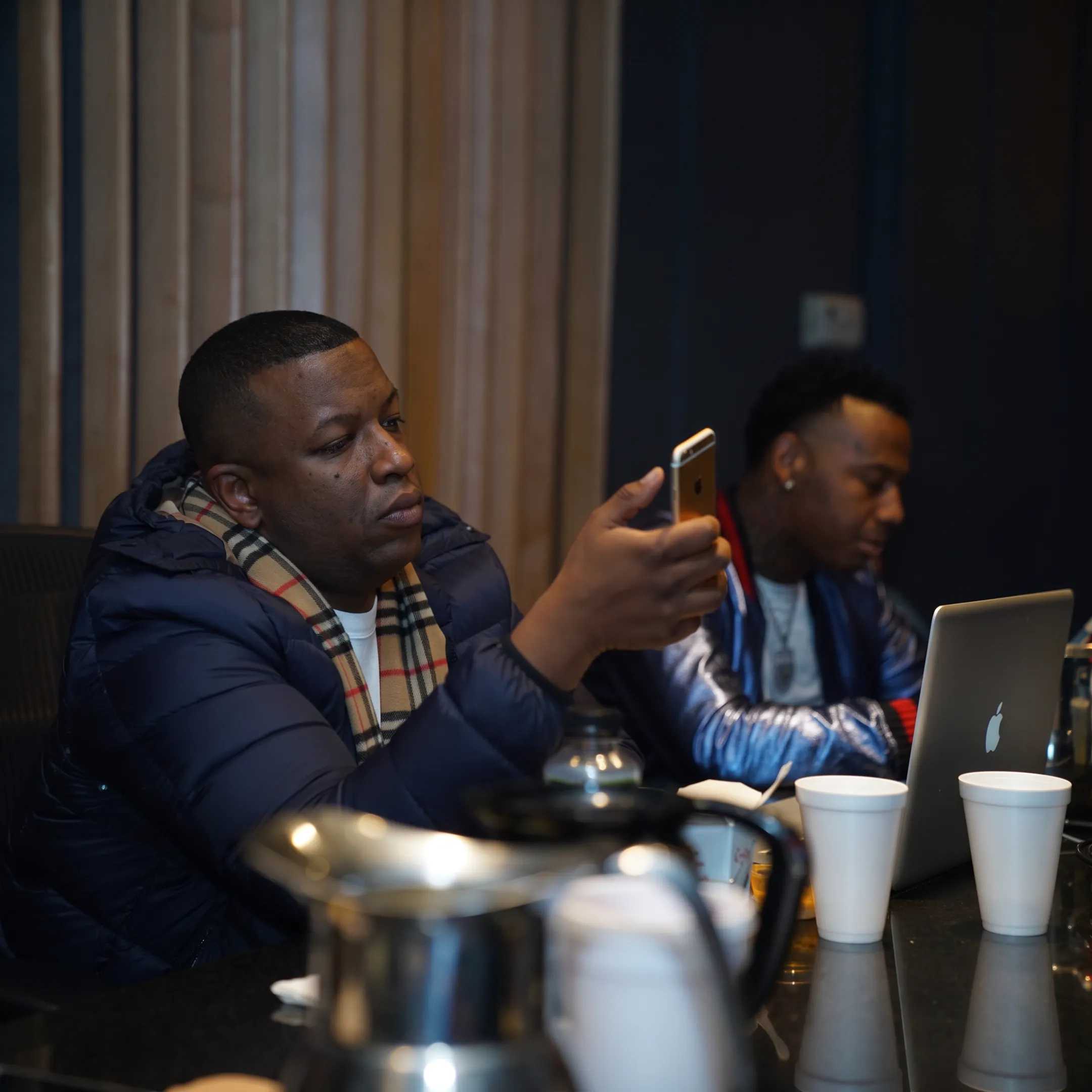 Music marketing team planning a rapper’s release campaign with promotional materials and studio equipment