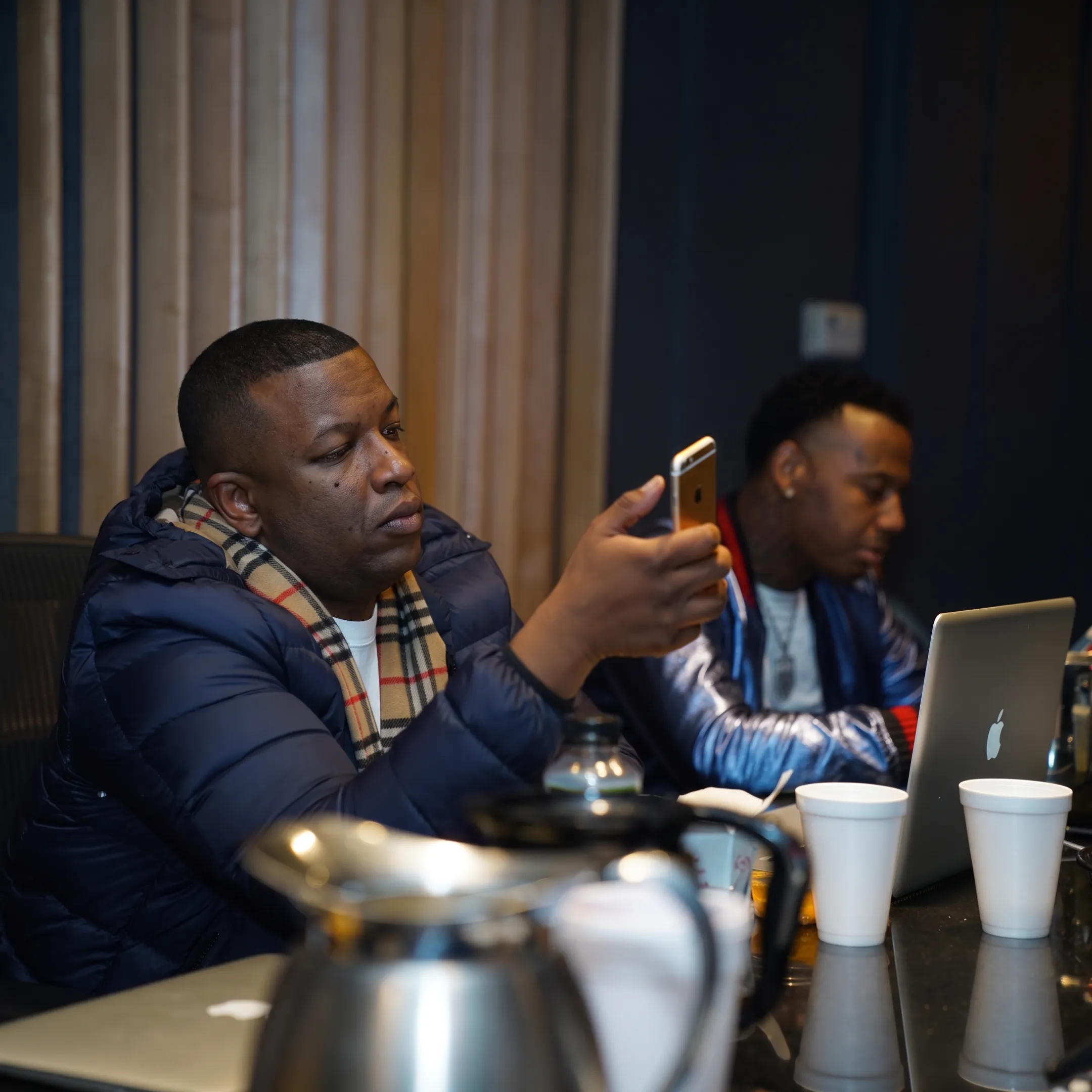 Independent artist recording music while a promotion team reviews a radio campaign