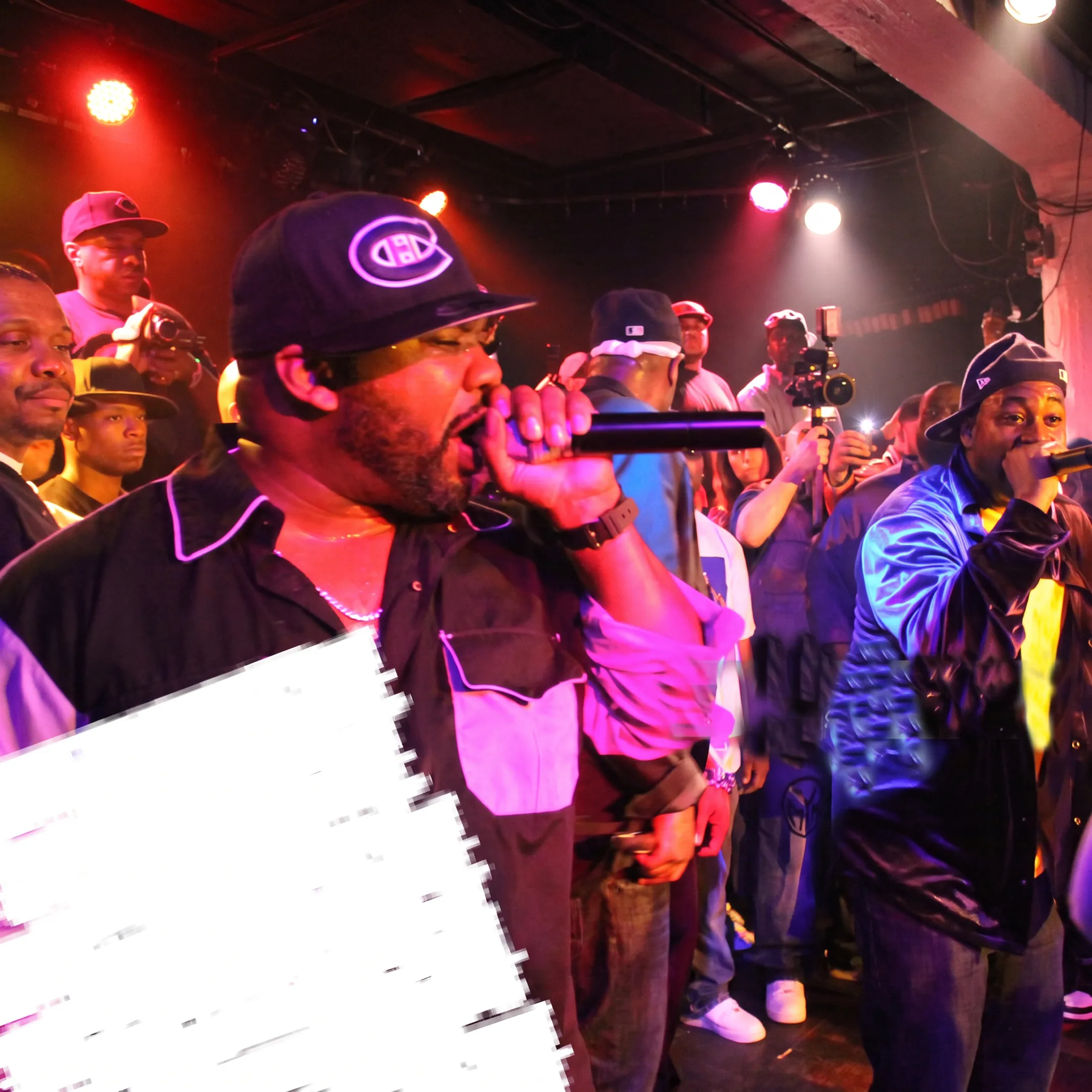 Rap artist performing onstage while booking agency professionals coordinate a live music event