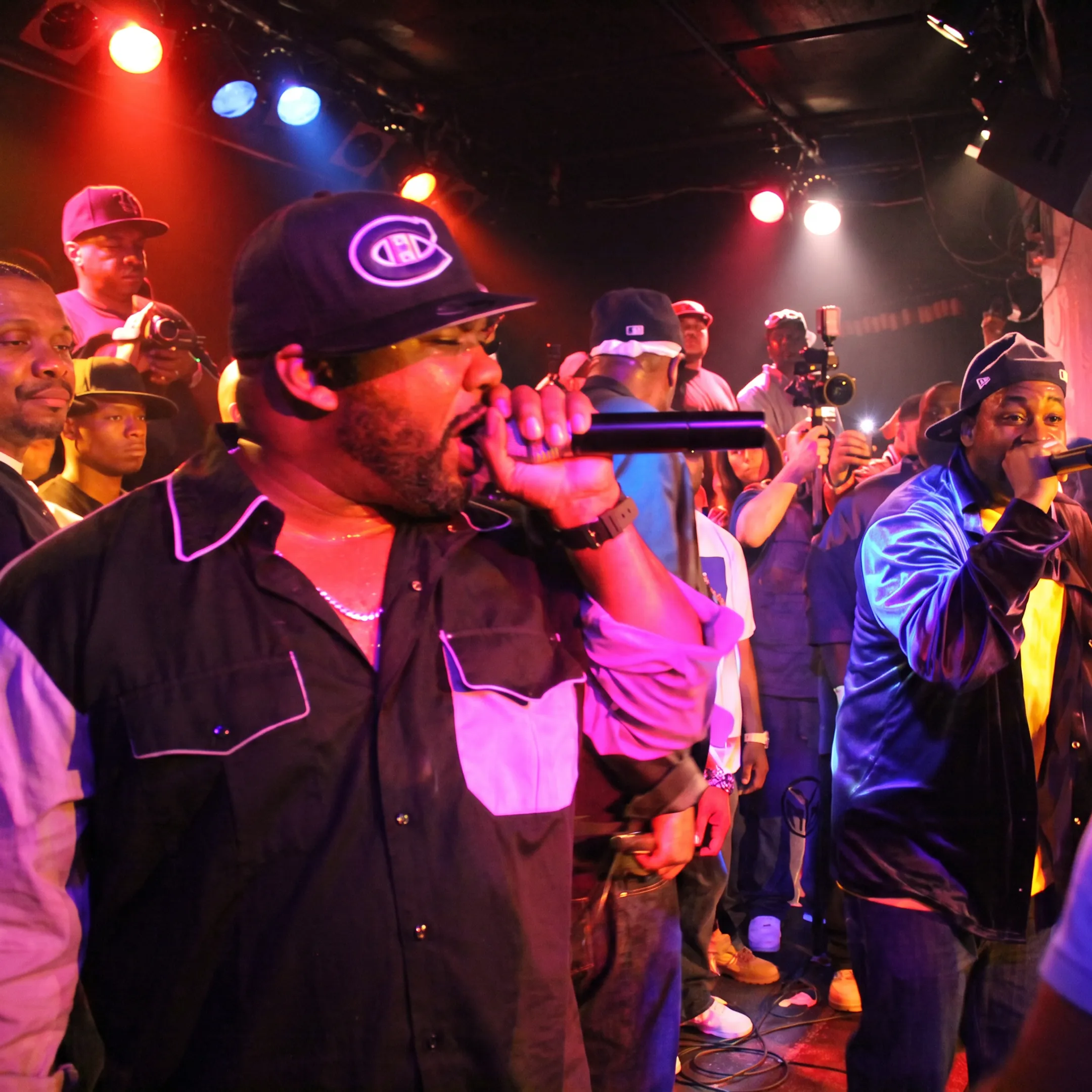 Artist performing onstage at a Miami music venue while industry professionals watch
