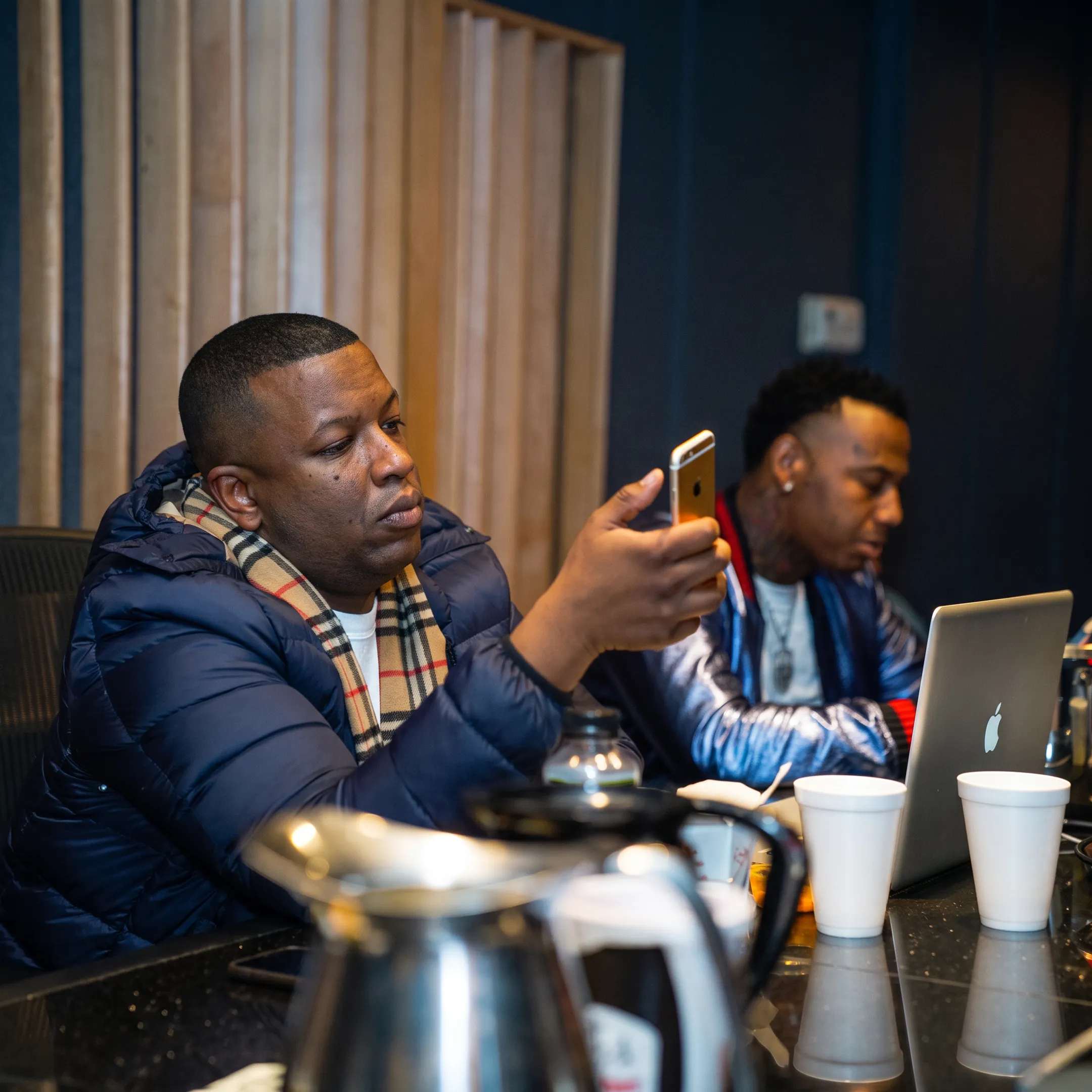 Music promotion strategist reviewing an artist campaign with a musician in a creative studio