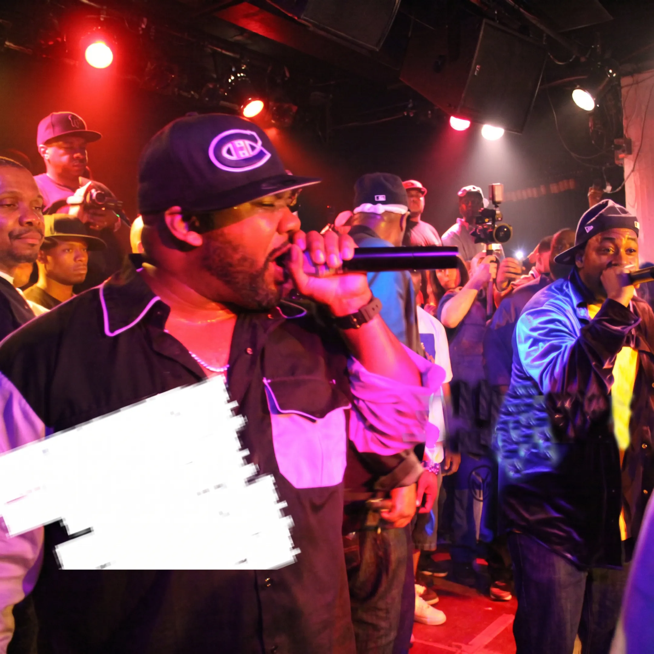 Rapper performing onstage at a live event before an engaged audience