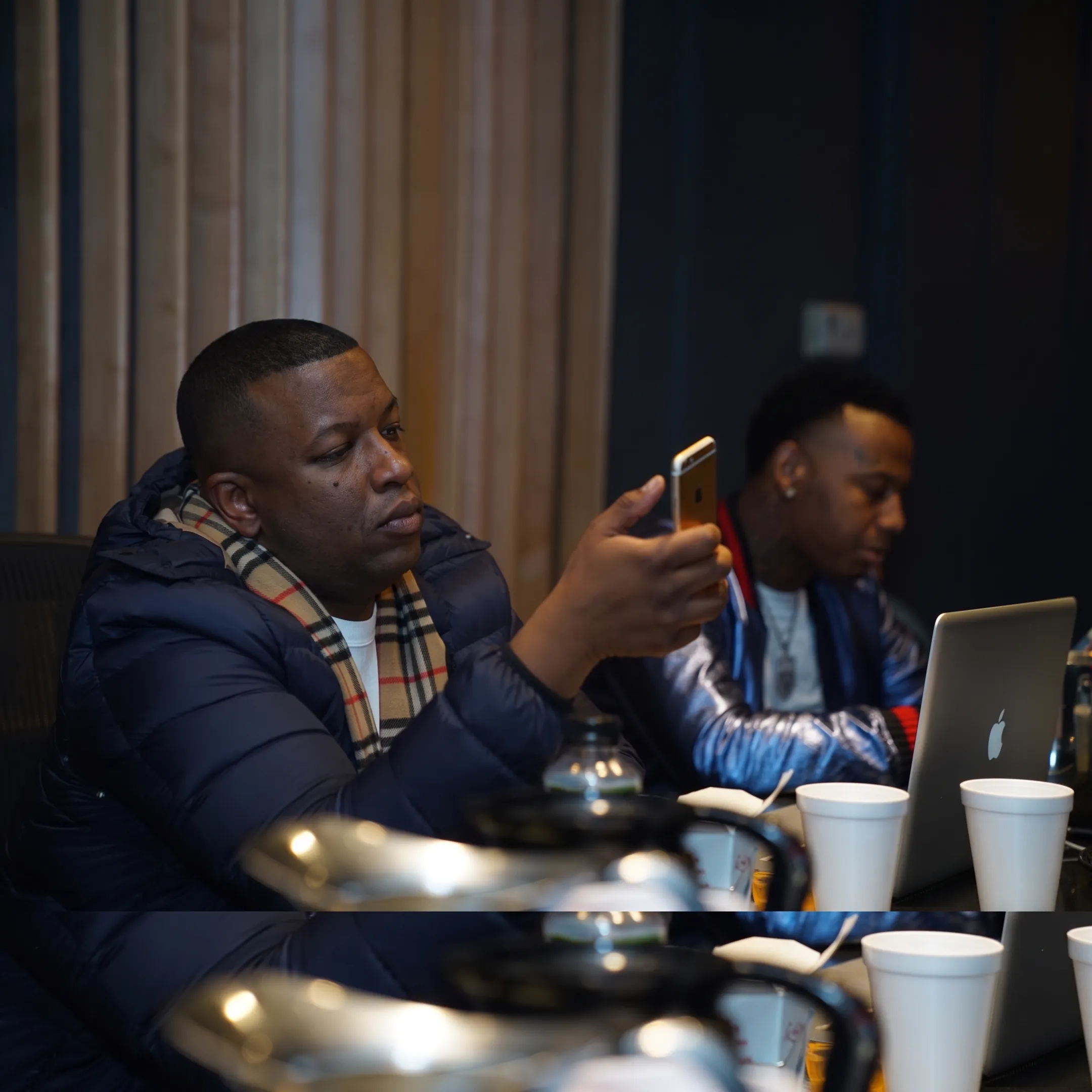 Artist and manager discussing release strategy beside studio equipment