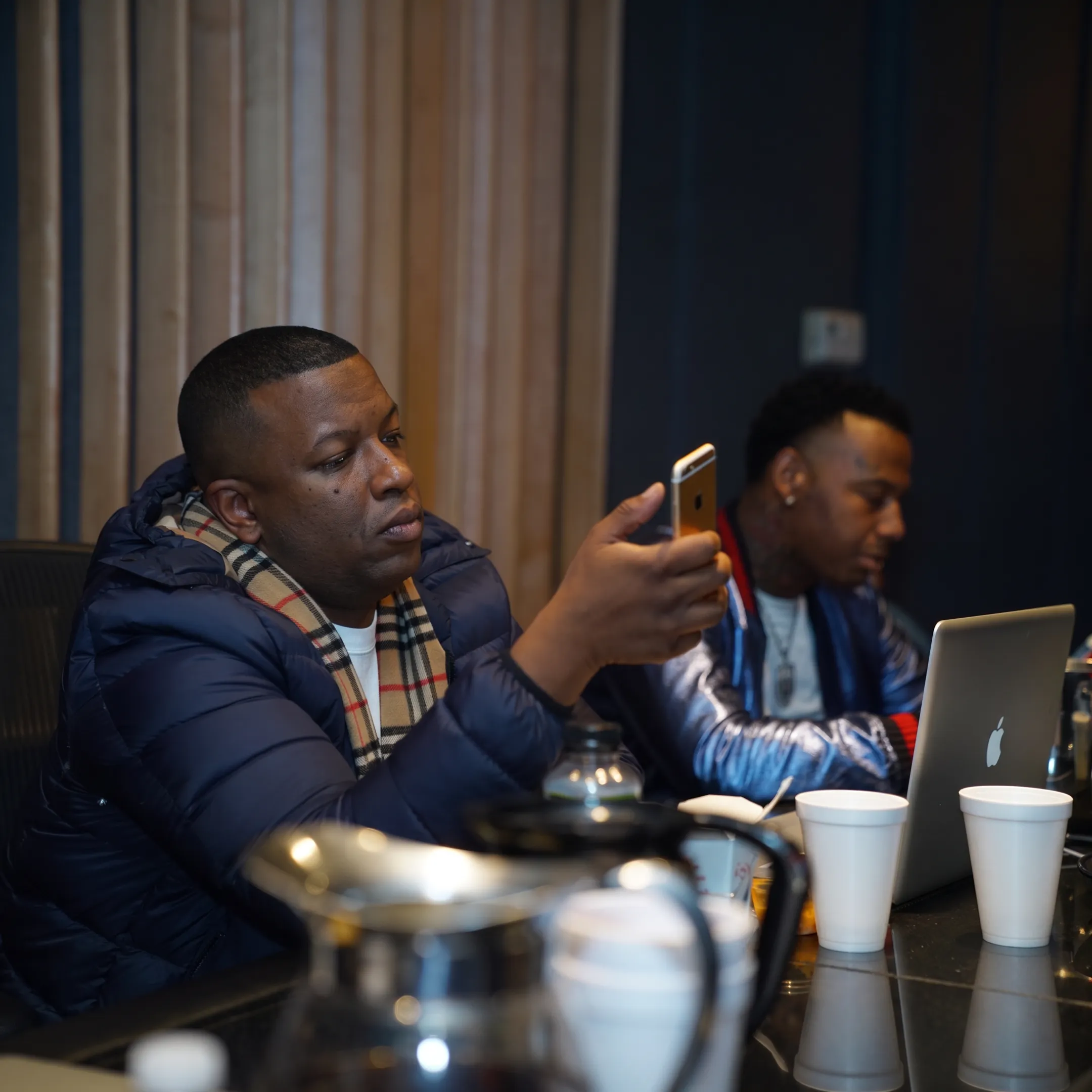 Music marketing strategist reviewing an artist campaign with promotional materials in a creative studio