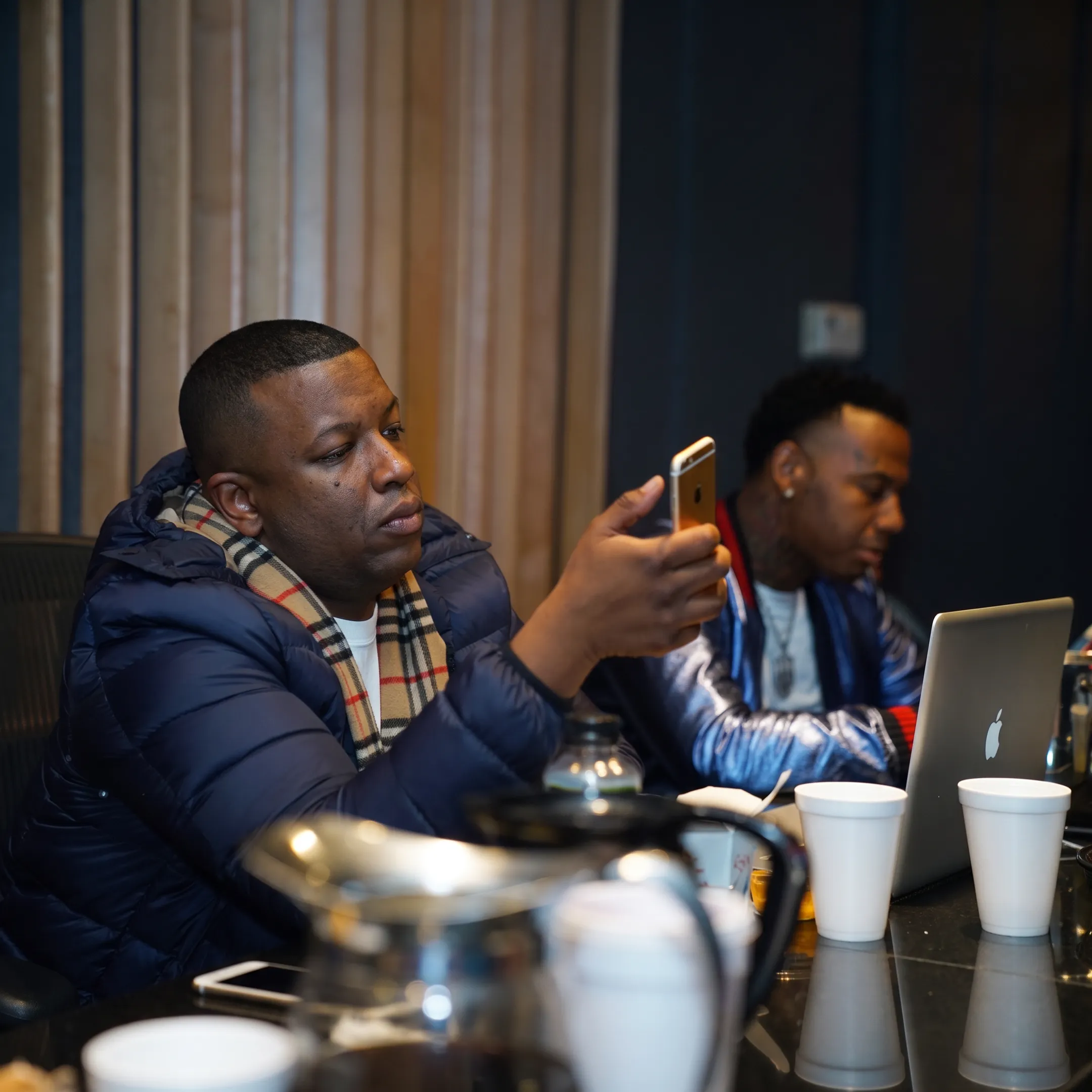 Manager and artist discussing release strategy at a studio table