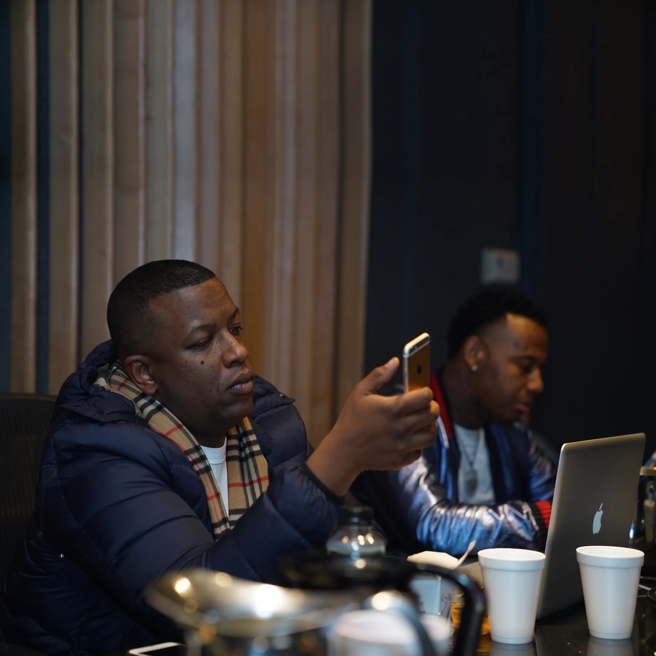 Music industry strategist reviewing an artist campaign with a performer in a creative studio