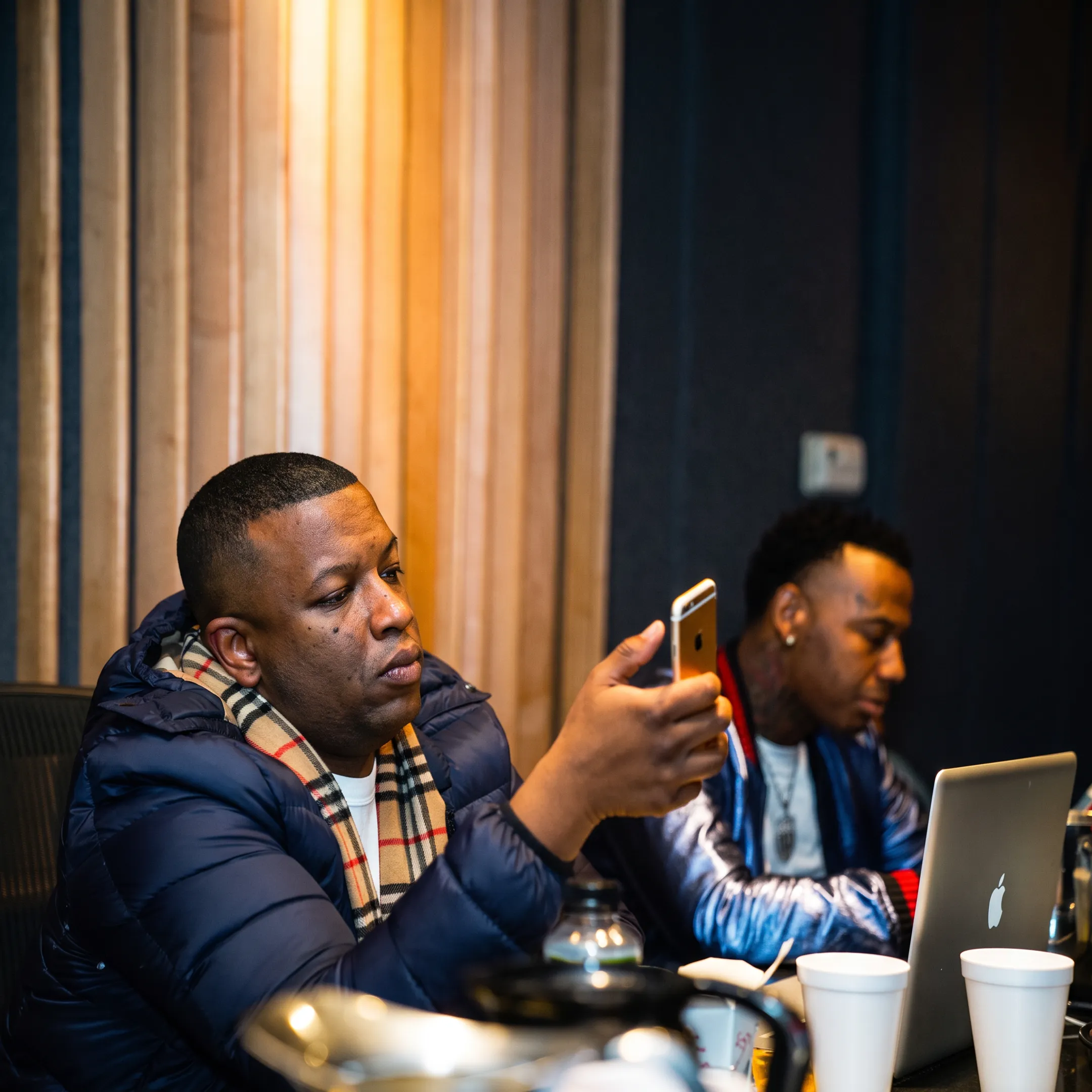 Music artist reviewing an album release campaign with a management team in a creative studio