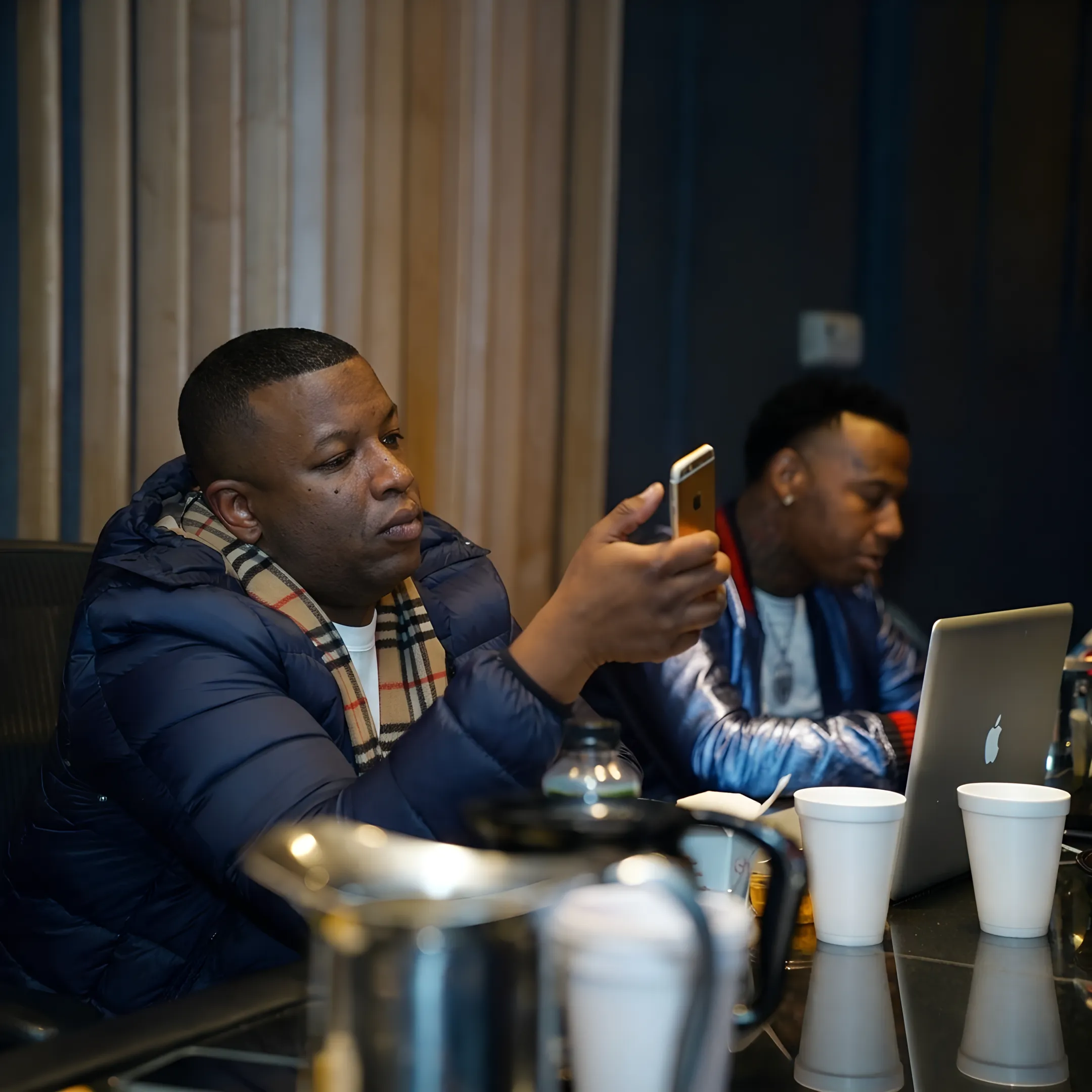 Artist manager advising a rapper during a focused studio consultation