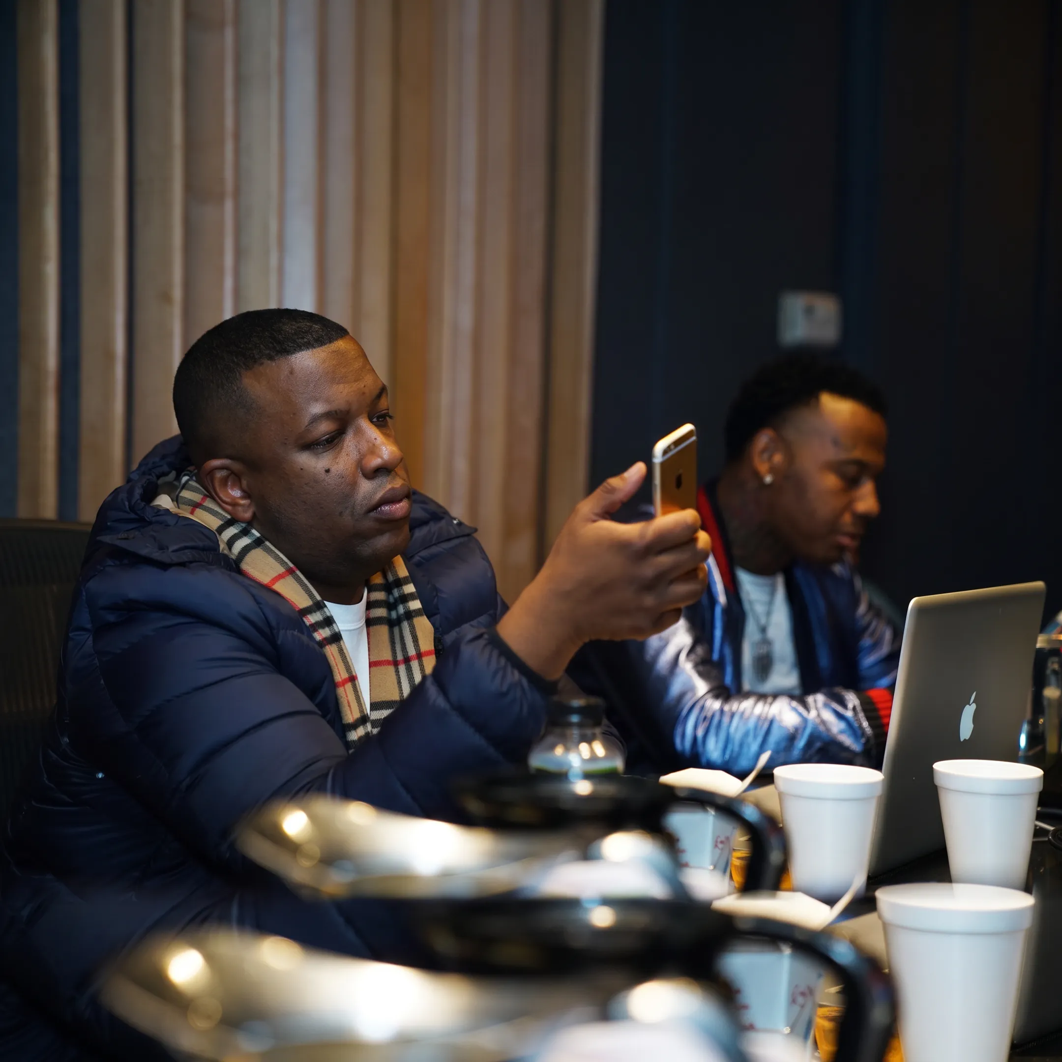 Music industry manager consulting with an artist in a professional studio setting