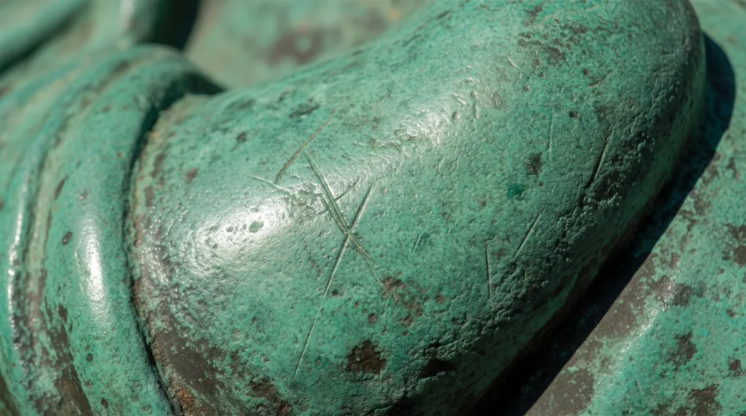 Green patina weathering on outdoor bronze statue surface