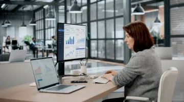 Business manager reviewing real-time analytics dashboard on desktop computer screen
