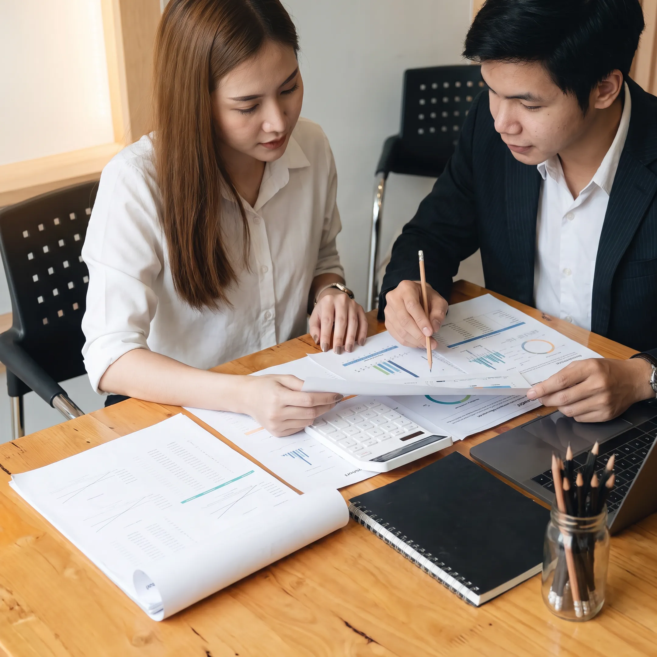 Business valuator reviewing company financial documents with a client