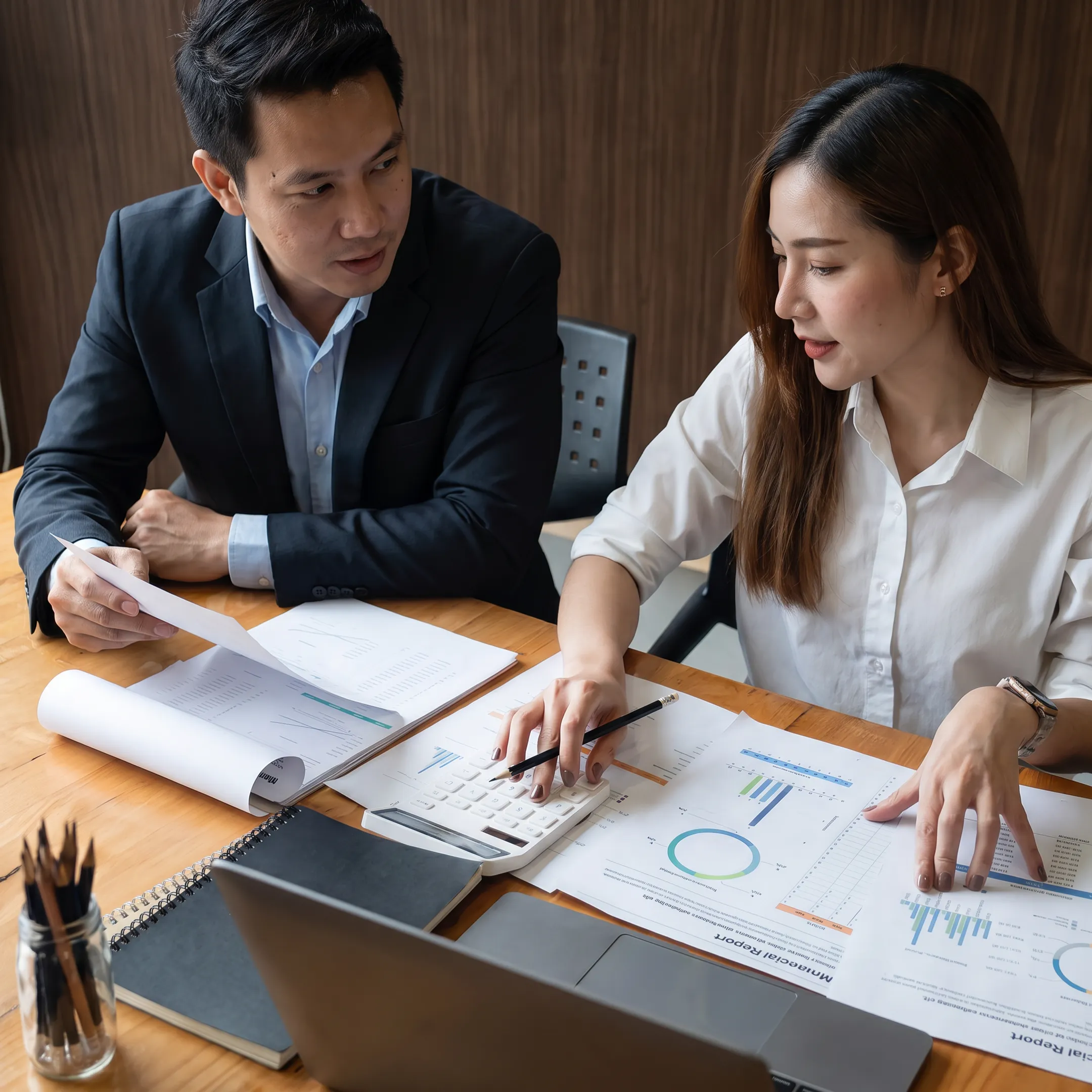 Business valuator reviewing financial documents with a Raleigh business owner
