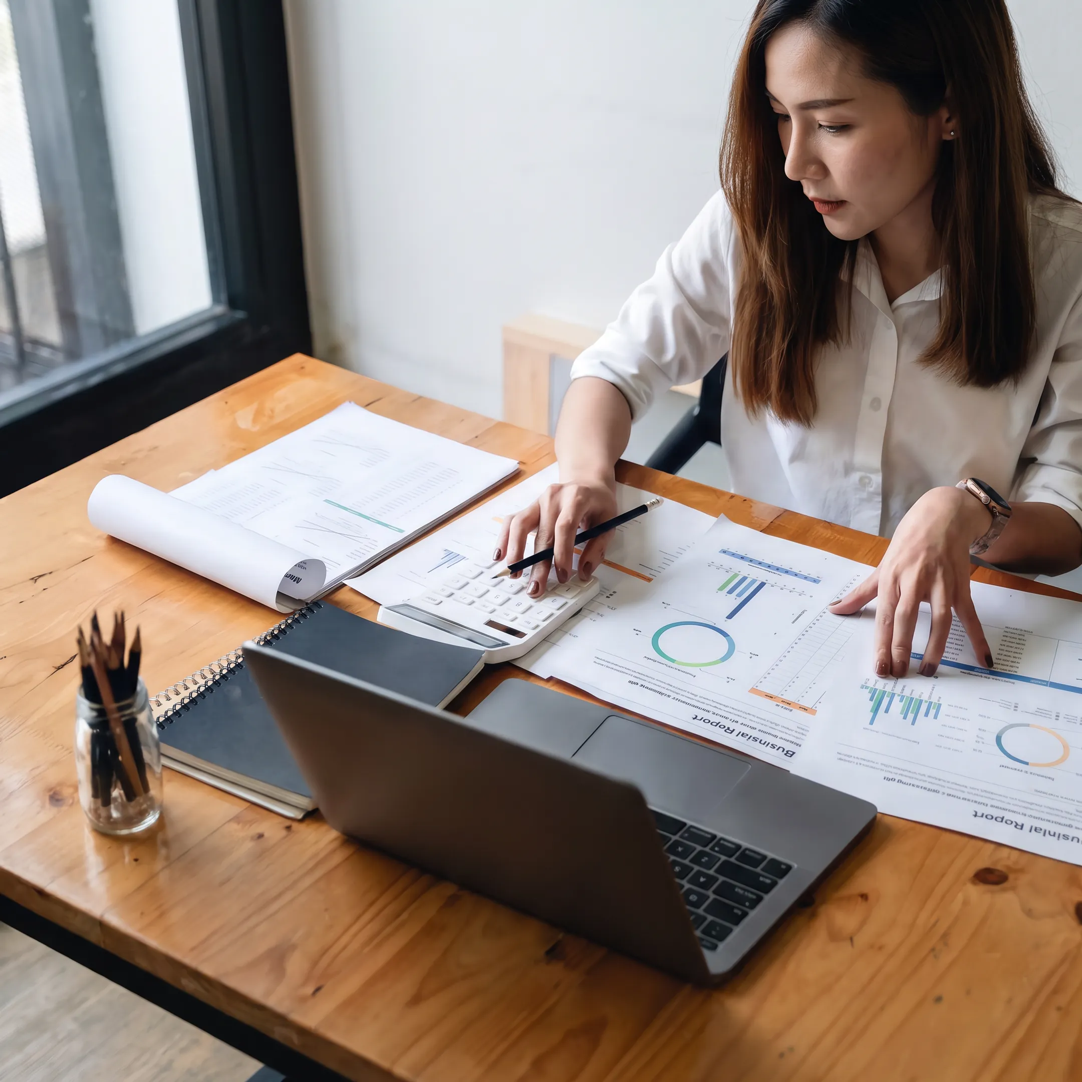 Valuation analyst examining business financial reports and ownership documents