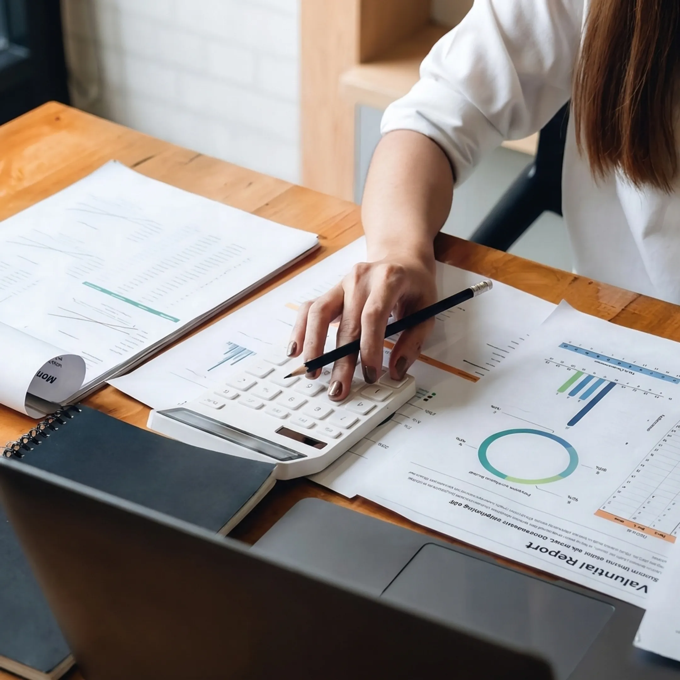 Valuator analyzing business financial records and valuation charts