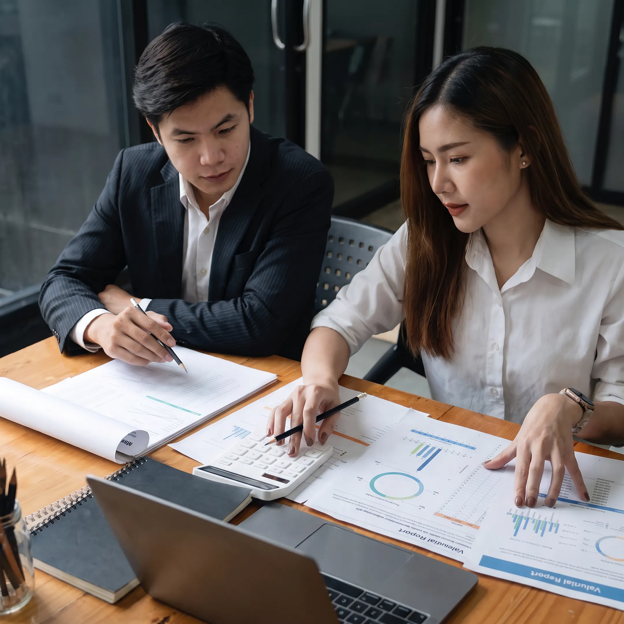 Business valuator reviewing financial documents with a business owner