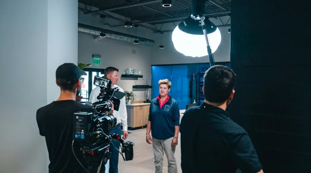 Professional video production crew setting up lighting and audio equipment on corporate shoot