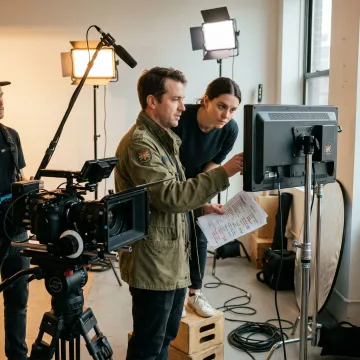 Video production team reviewing footage on set