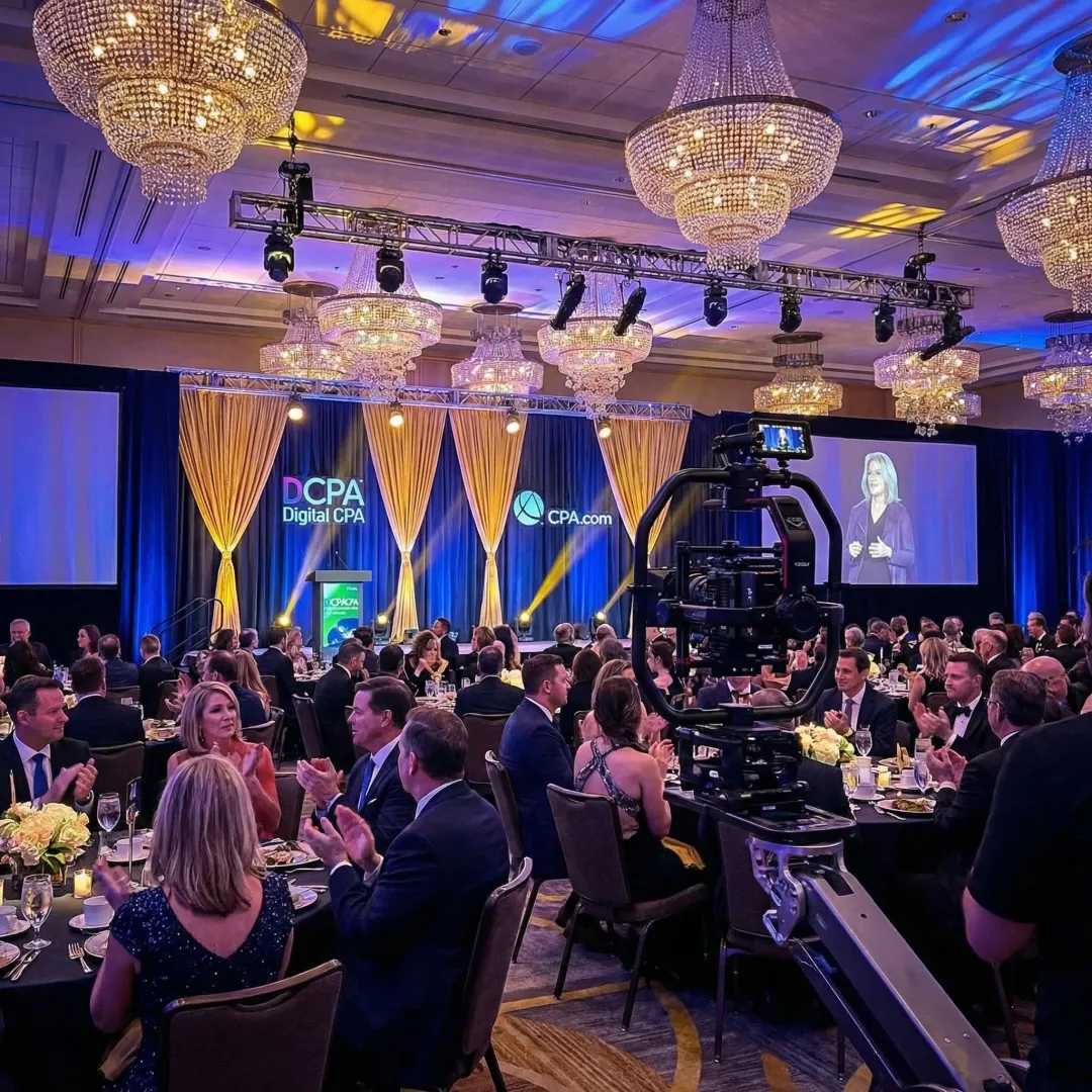 Corporate event being filmed with professional video equipment and lighting